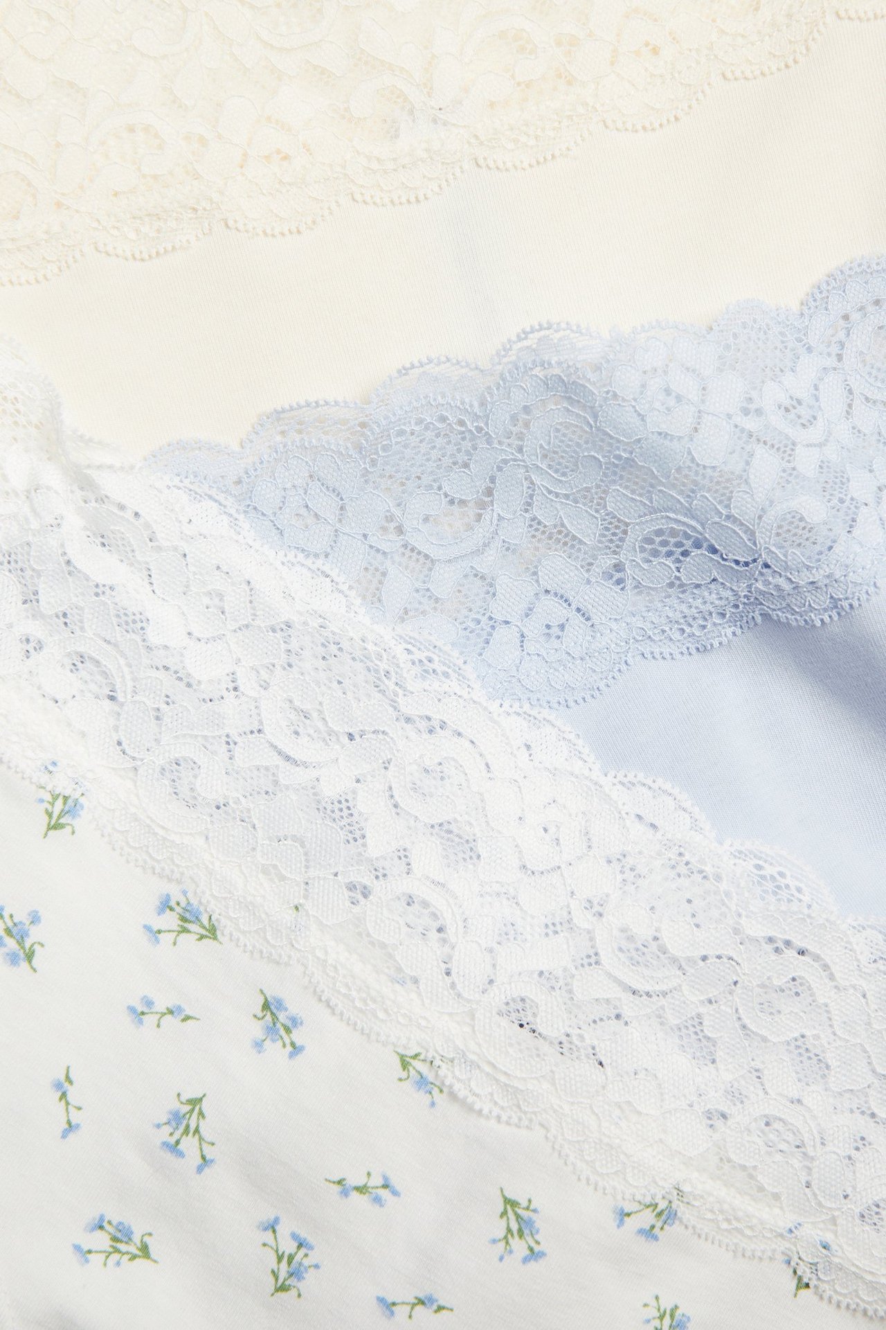 Närbild av tre hipstertrosor: offwhite med spets, ljusblå med spets och offwhite med blått blommönster.