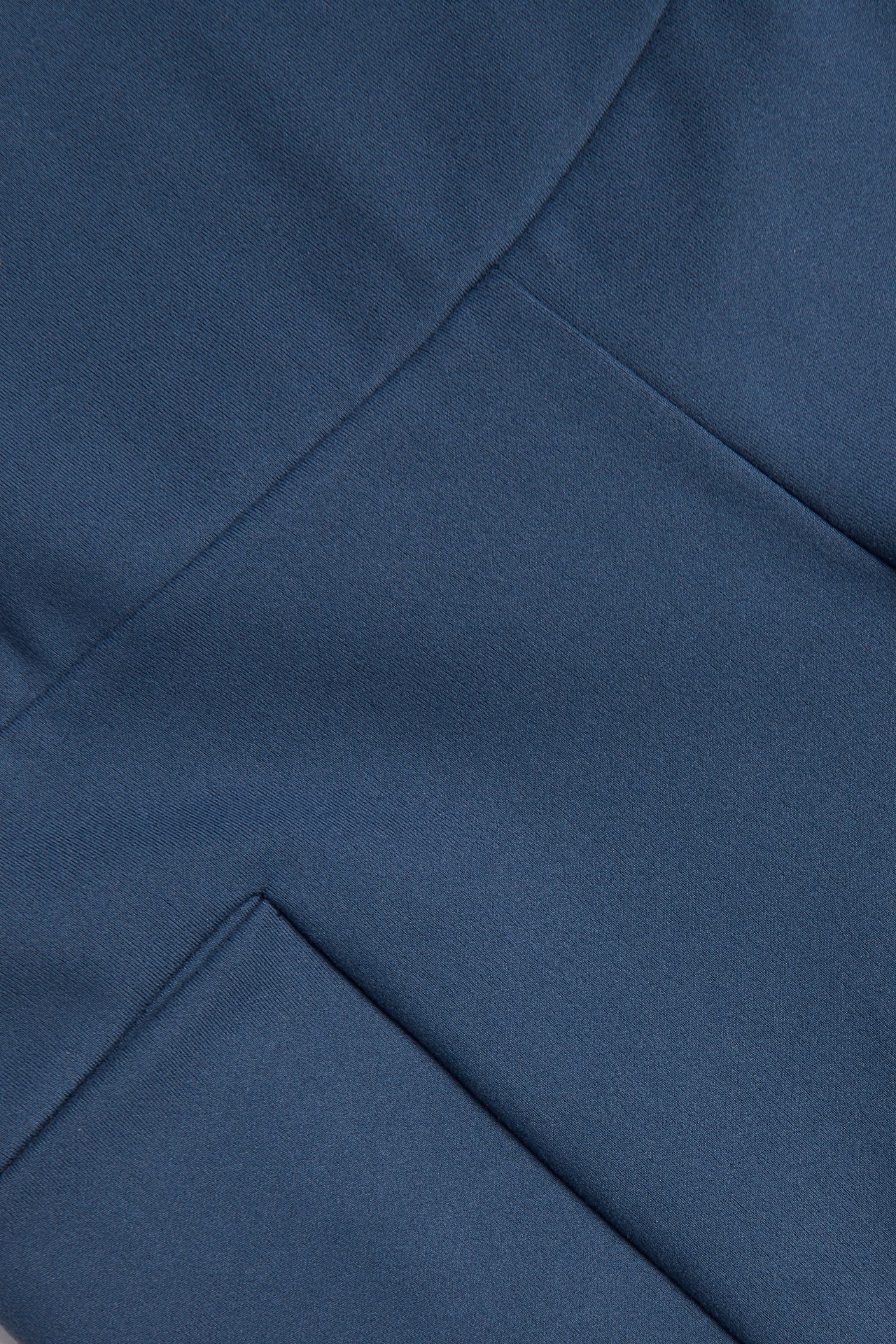 Zbliżenie na niebieskie szorty kolarskie z miękkiego dżerseju ze stretchem, widocznymi szwami i kieszenią na telefon.