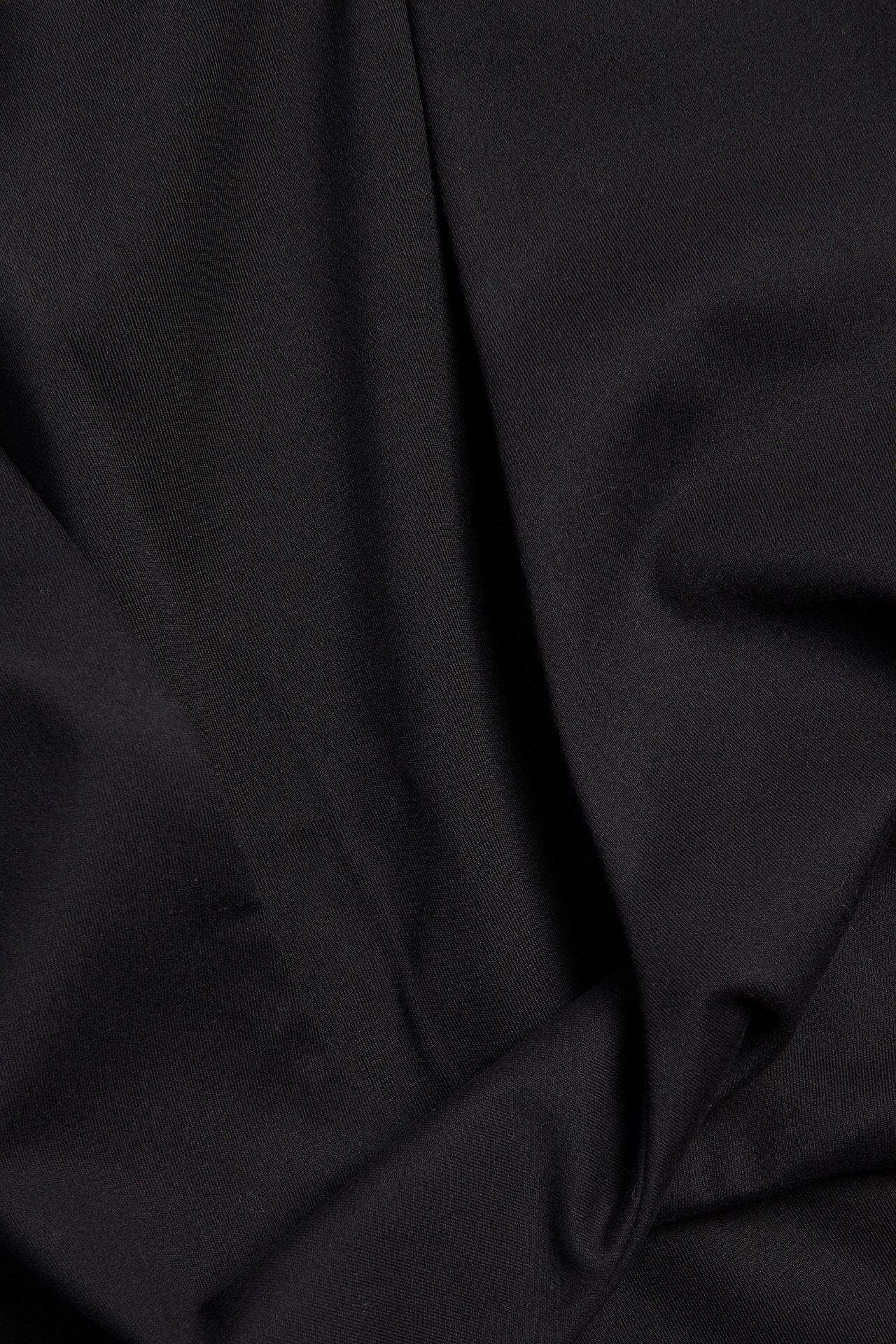 Närbild av svart mjuk stretchjersey med matt yta och diskret diagonal struktur.