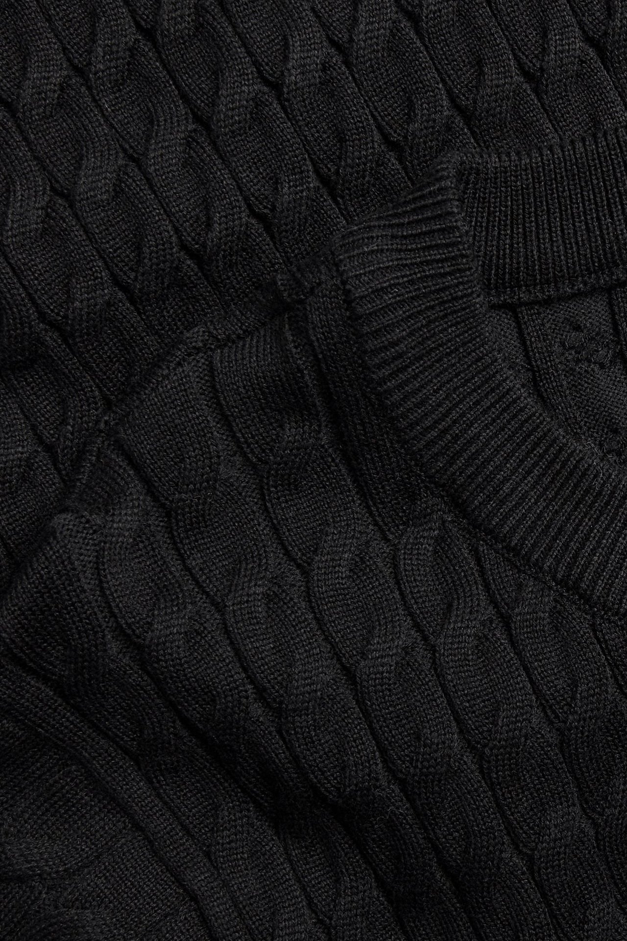 Zbliżenie na czarną sukienkę ze splotem warkoczowym z prążkowanym dekoltem.