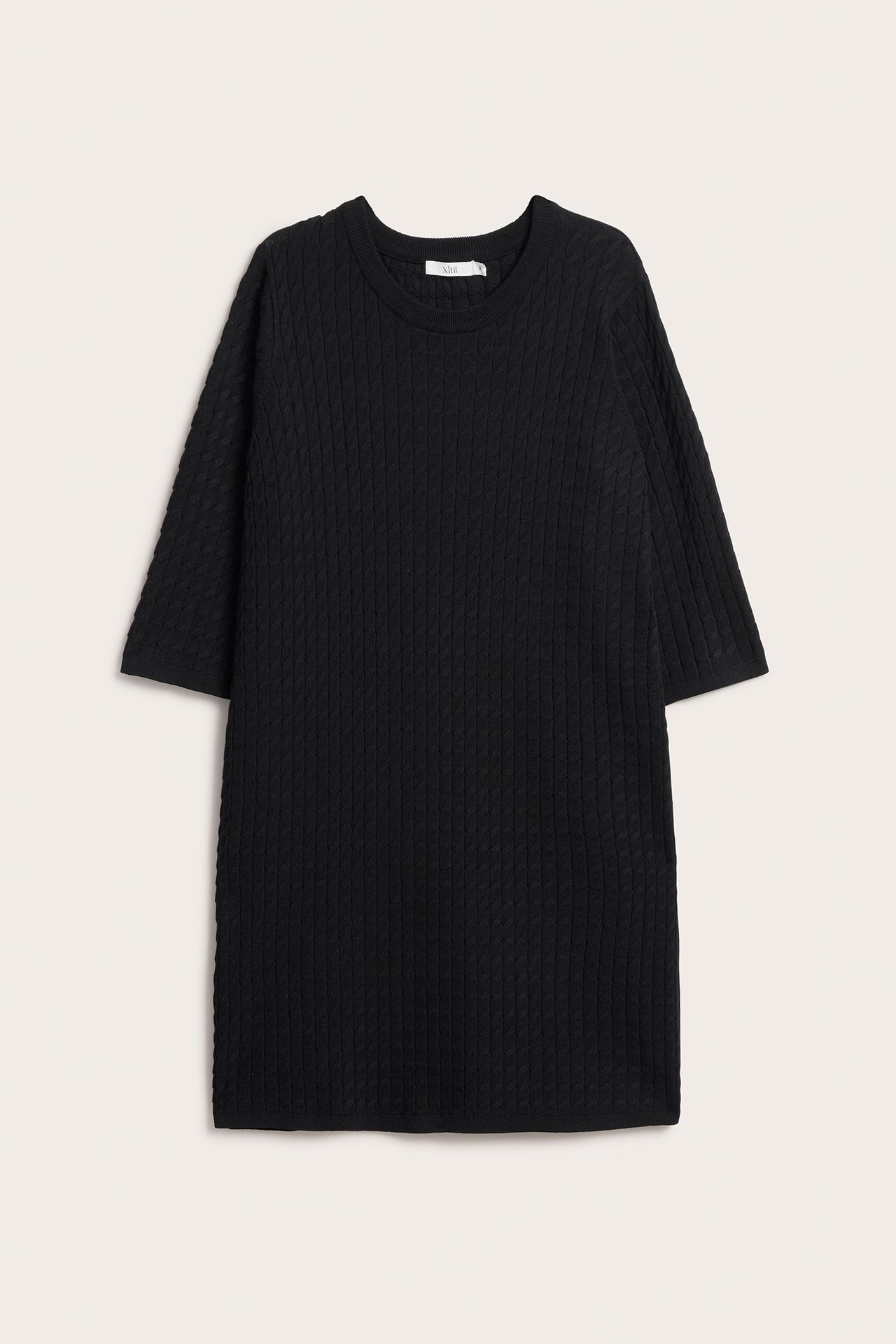 Frontvisning av en svart kabelstrikket kjole i viskoseblanding med rund hals og korte ermer.