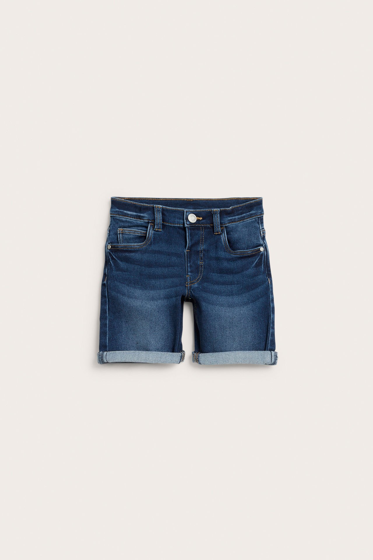 Framifrån: Barns mörkblå denimtrikåshorts med uppvikta benslut och knäppning.