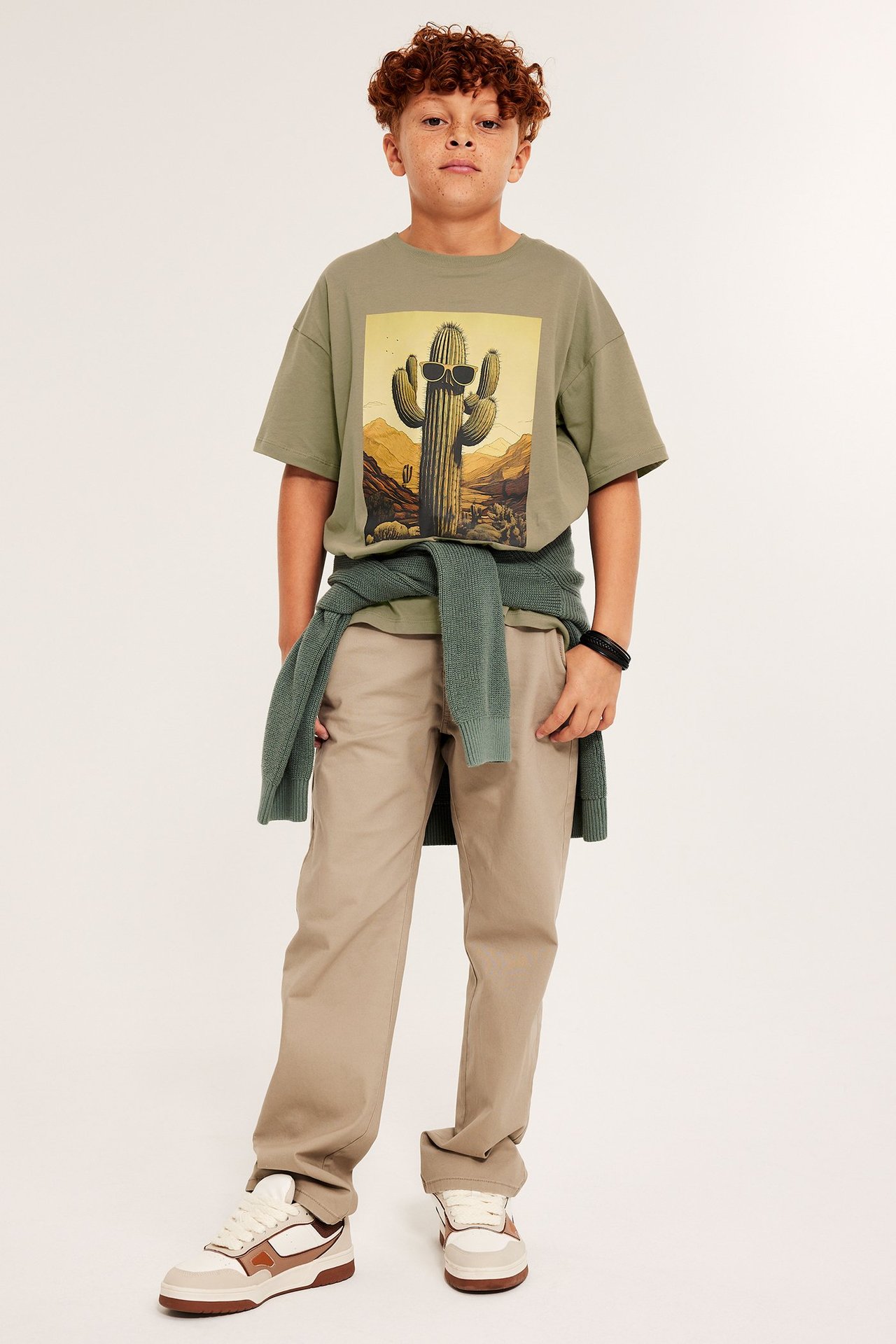 Barn t-shirt med tryck av en kaktus med solglasögon, i mörkbeige färg, frontvy.