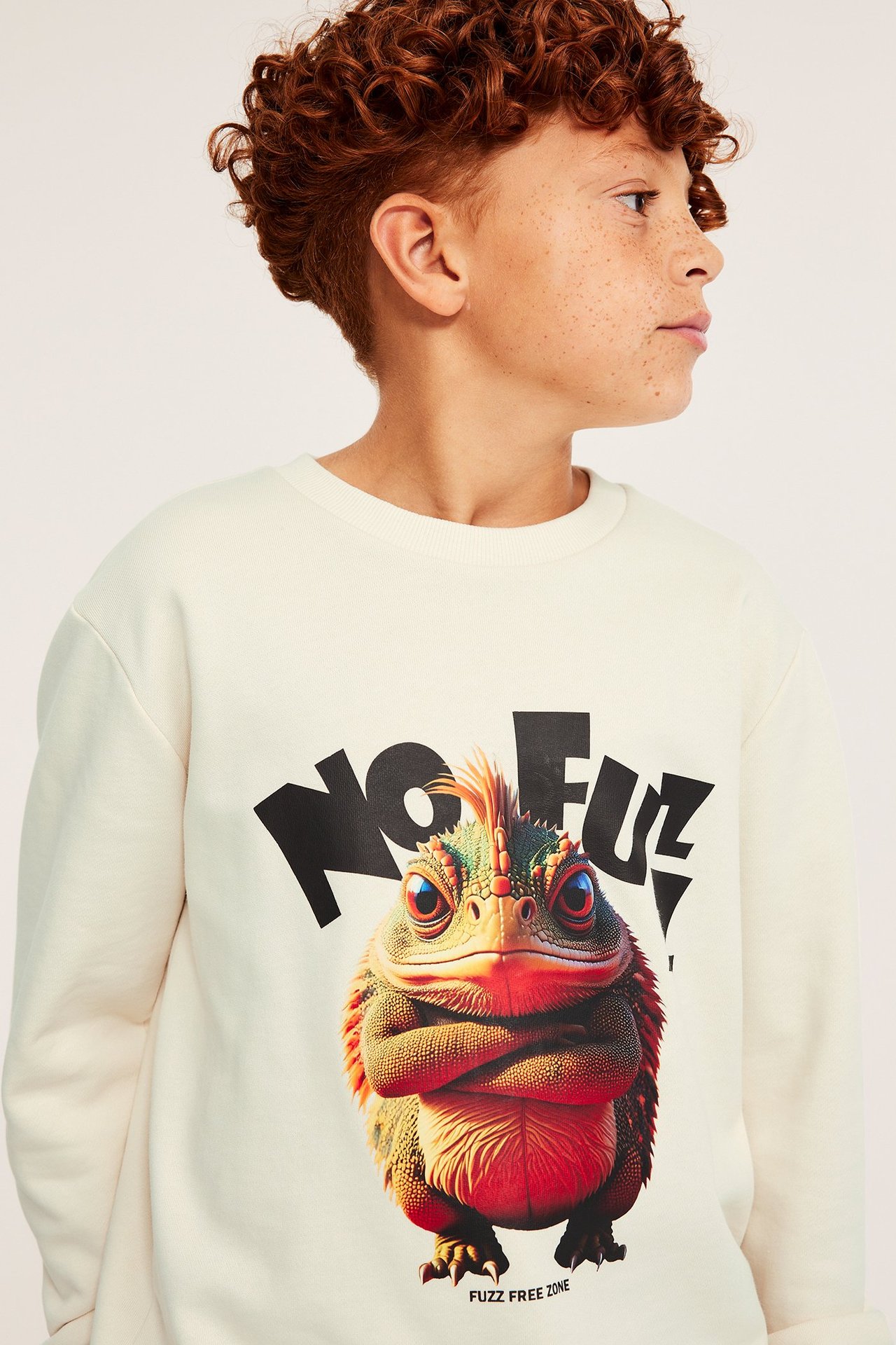 Świetlista beżowa bawełniana bluza dziecięca z dużym kolorowym nadrukiem.