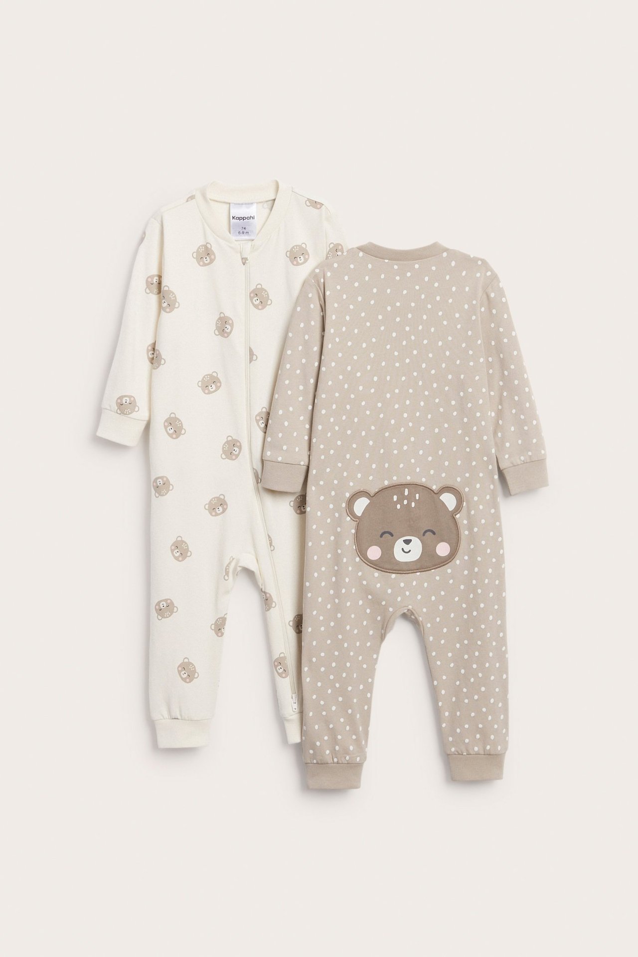 To babyrompere: en offwhite med bjørnetrykk og 2-veis glidelås; en beige med prikker og bjørneapplikasjon.
