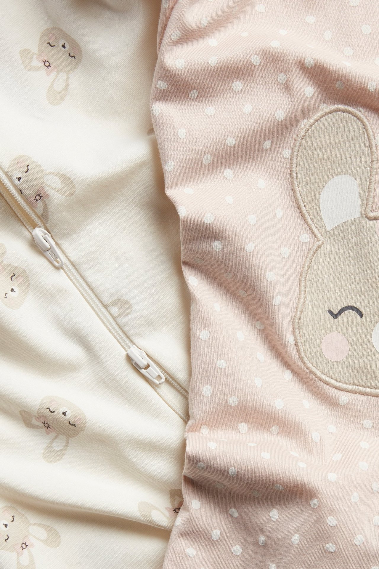 Baby-pysjamas: rosa prikkete med kaninapplikasjon; off-white med kanintrykk, toveis glidelås.