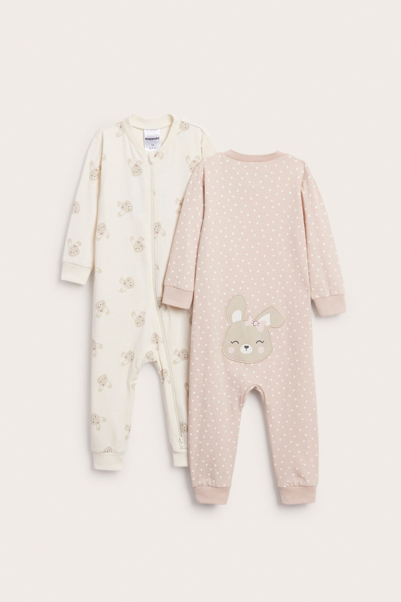 Forfra, to babyrompers: en beige med kanintrykk og en rosa med prikker og kaninapplikasjon bak.