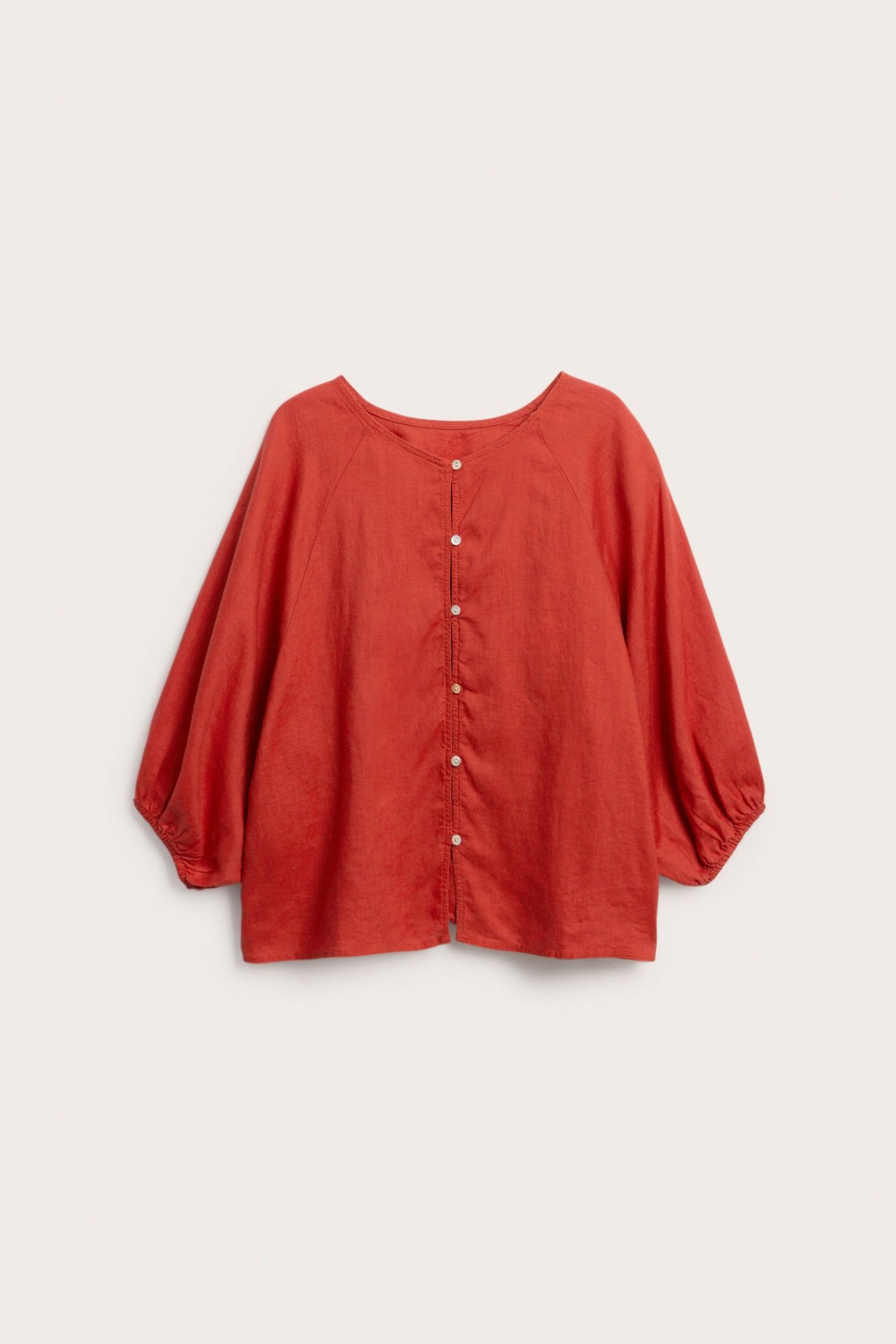 Czerwona lniana bluzka z okrągłym dekoltem, raglanowymi rękawami i białymi guzikami z przodu.