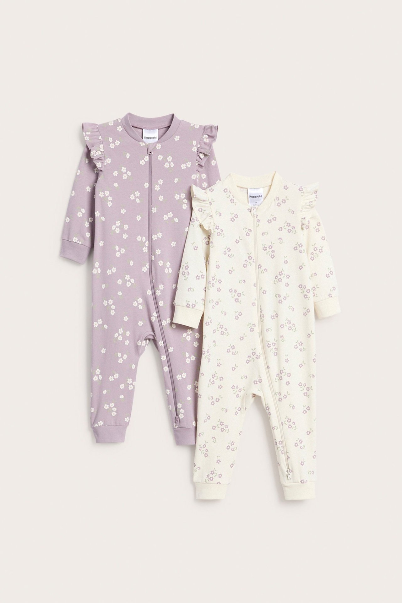 Framifrån två babyrompers. Lila och gräddvita med blommigt tryck, axelvolanger och tvåvägsdragkedja.