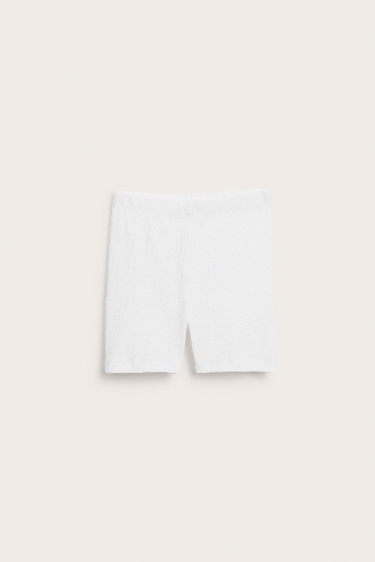 Framifrån, vita ribbade enfärgade cykelshorts liggande platt.