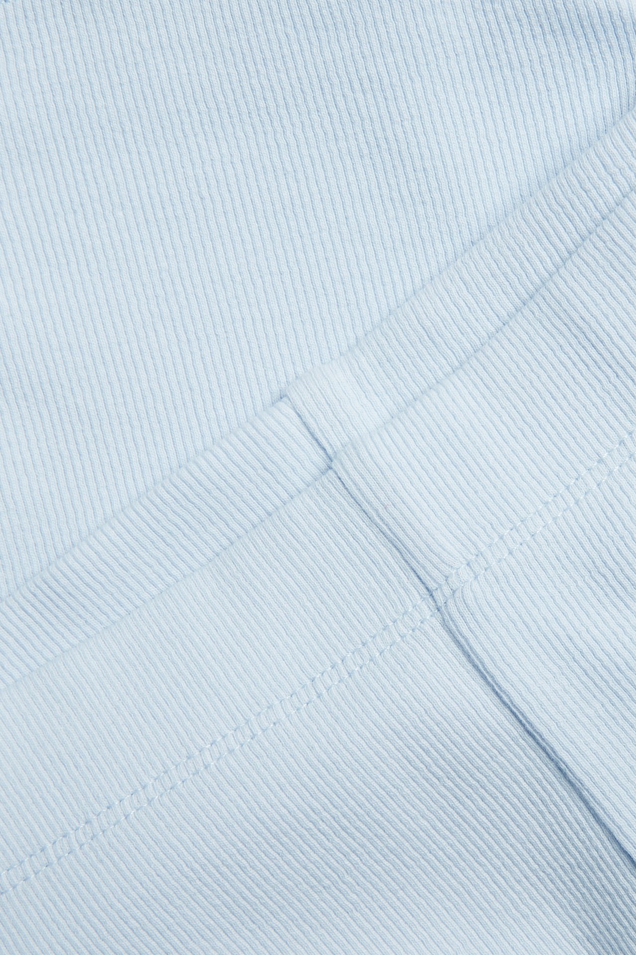 Närbild av ljusblått ribbat cykelshorts-tyg med synliga sömmar.