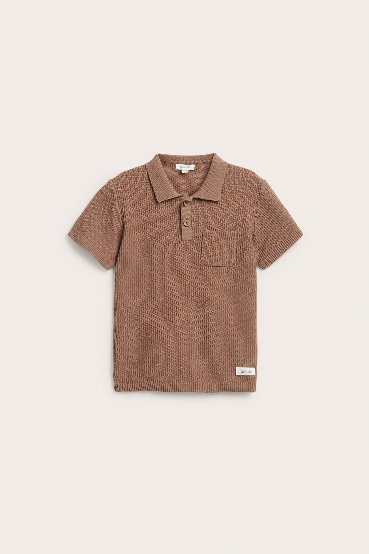 Edestäpäin ruskea neulottu lyhythihainen pikeepaita kauluksella, kahdella napilla ja rintataskulla.