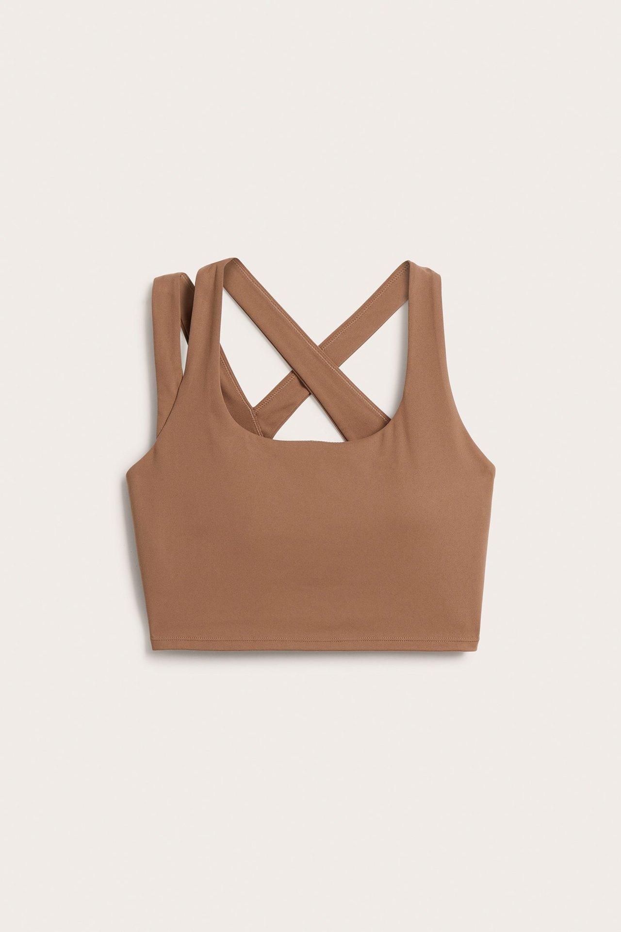 Frontvisning av en ensfarget brun sportstopp med firkantet utringning og brede kryssede skulderstropper bak.