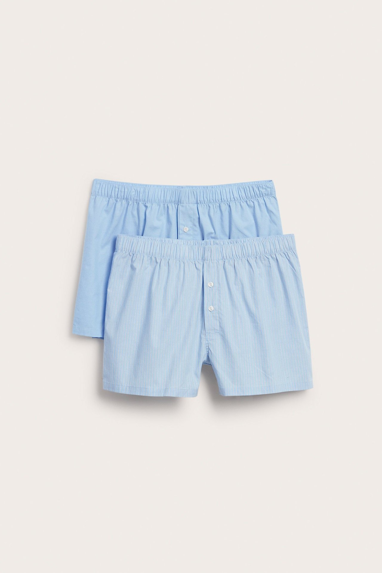 Framsida av herrarnas tvåpack vävda boxerkalsonger: en ljusblå, en ljusblå randig med knäppt gylf.