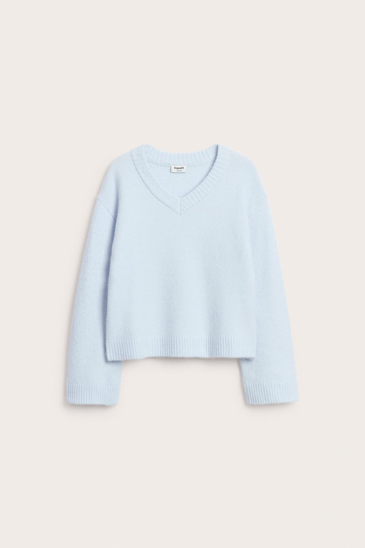 Edestä, vaaleansininen neulottu V-kaula-aukkoinen villapaita uurretuilla hihansuilla ja helmalla.