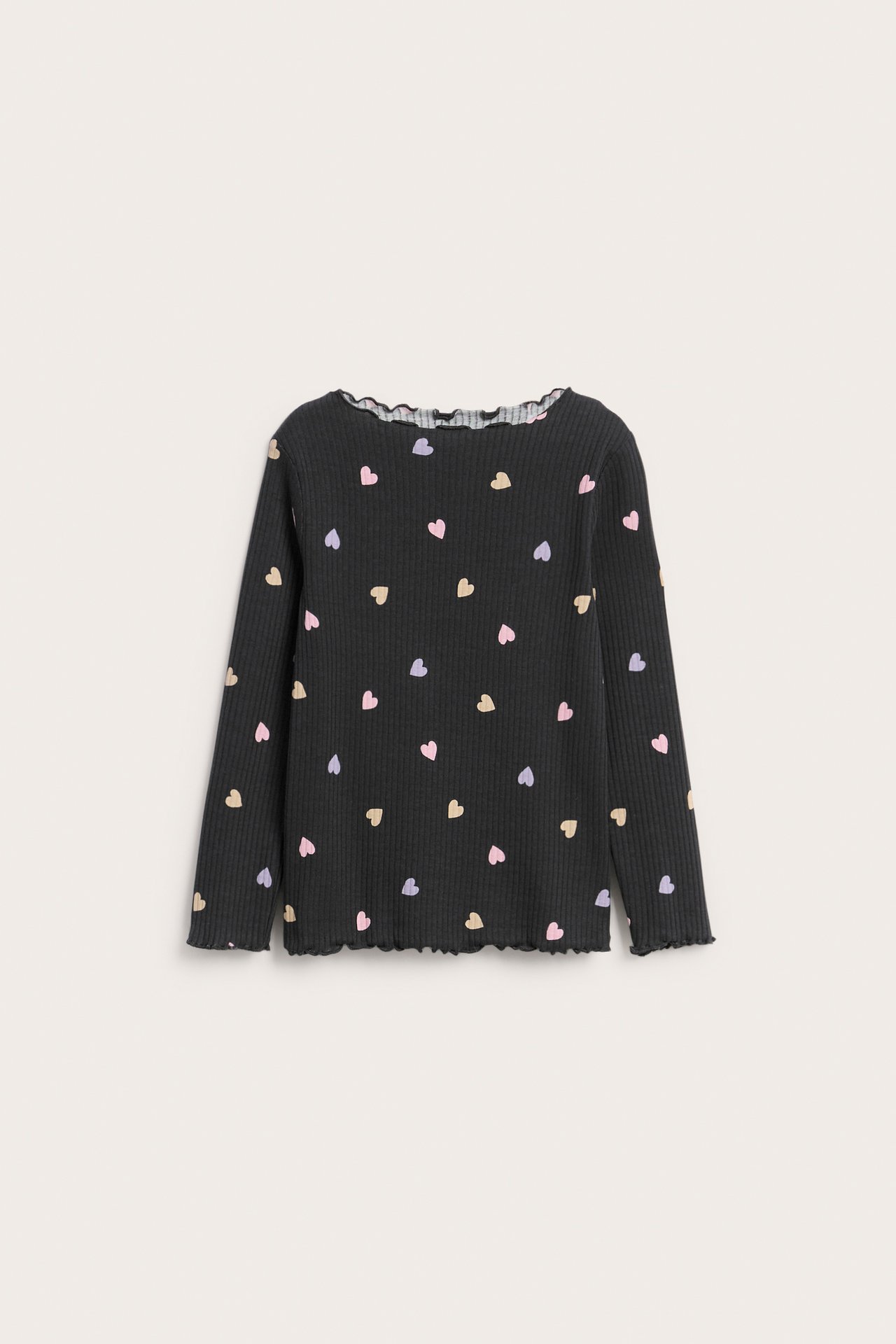 Forfra: svart ribbet langermet topp for barn med fargerikt hjerteprint og babylock-kanter.