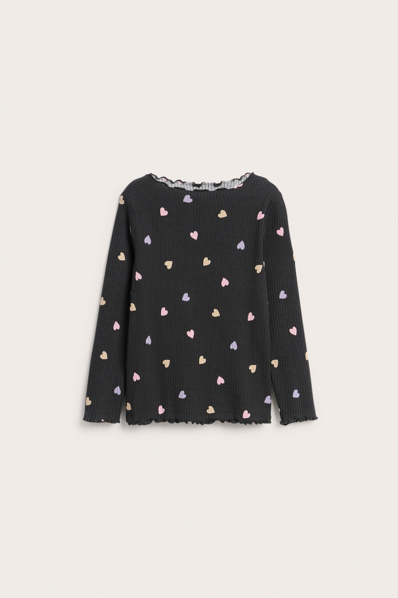Framsida av en svart ribbad långärmad topp för barn med färgglatt hjärtmönster och babylocksömmar.