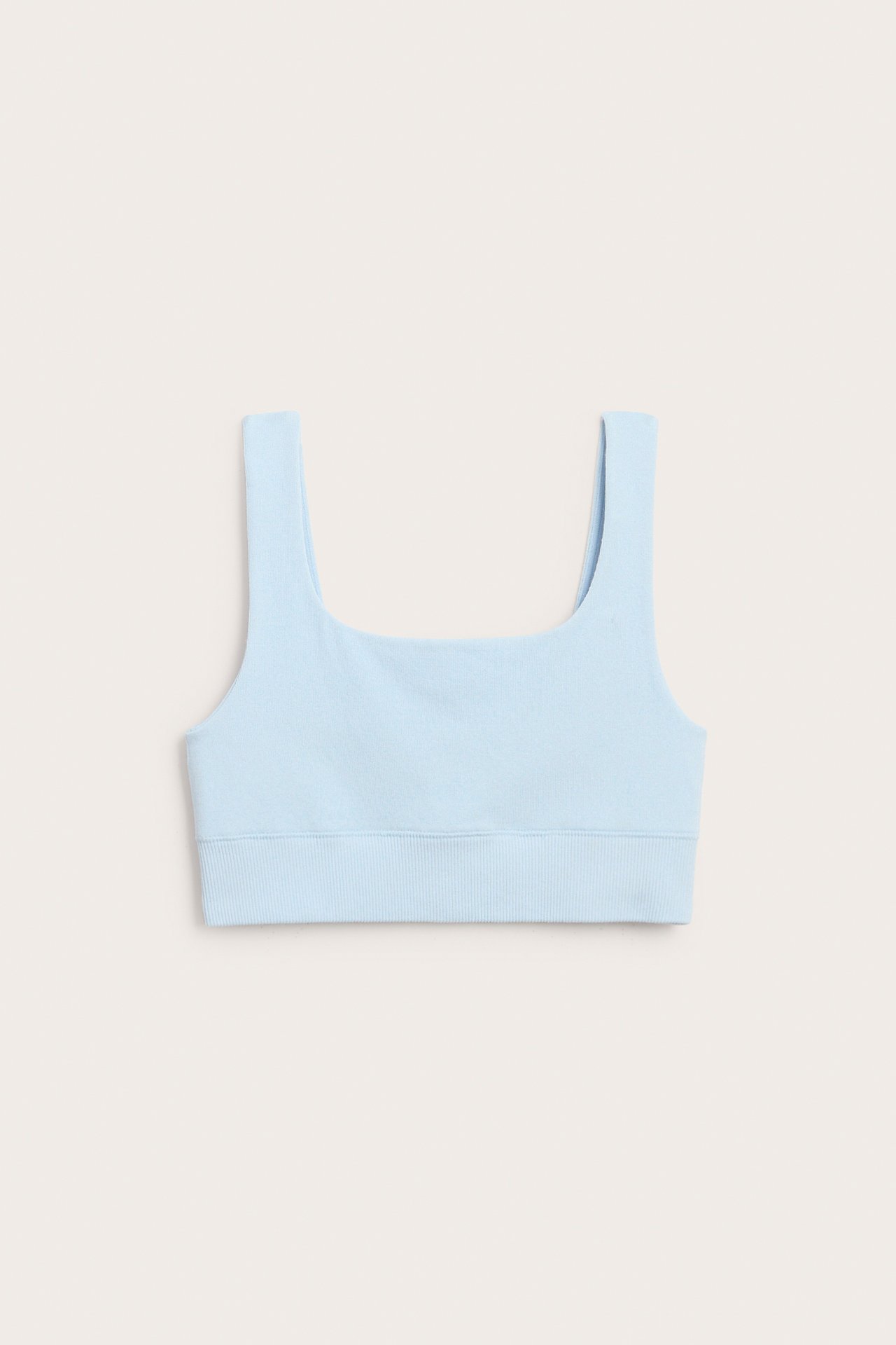 Frontvisning av en lyseblå BH-topp i bomullsblanding med firkantet halslinning og ribbet kant.