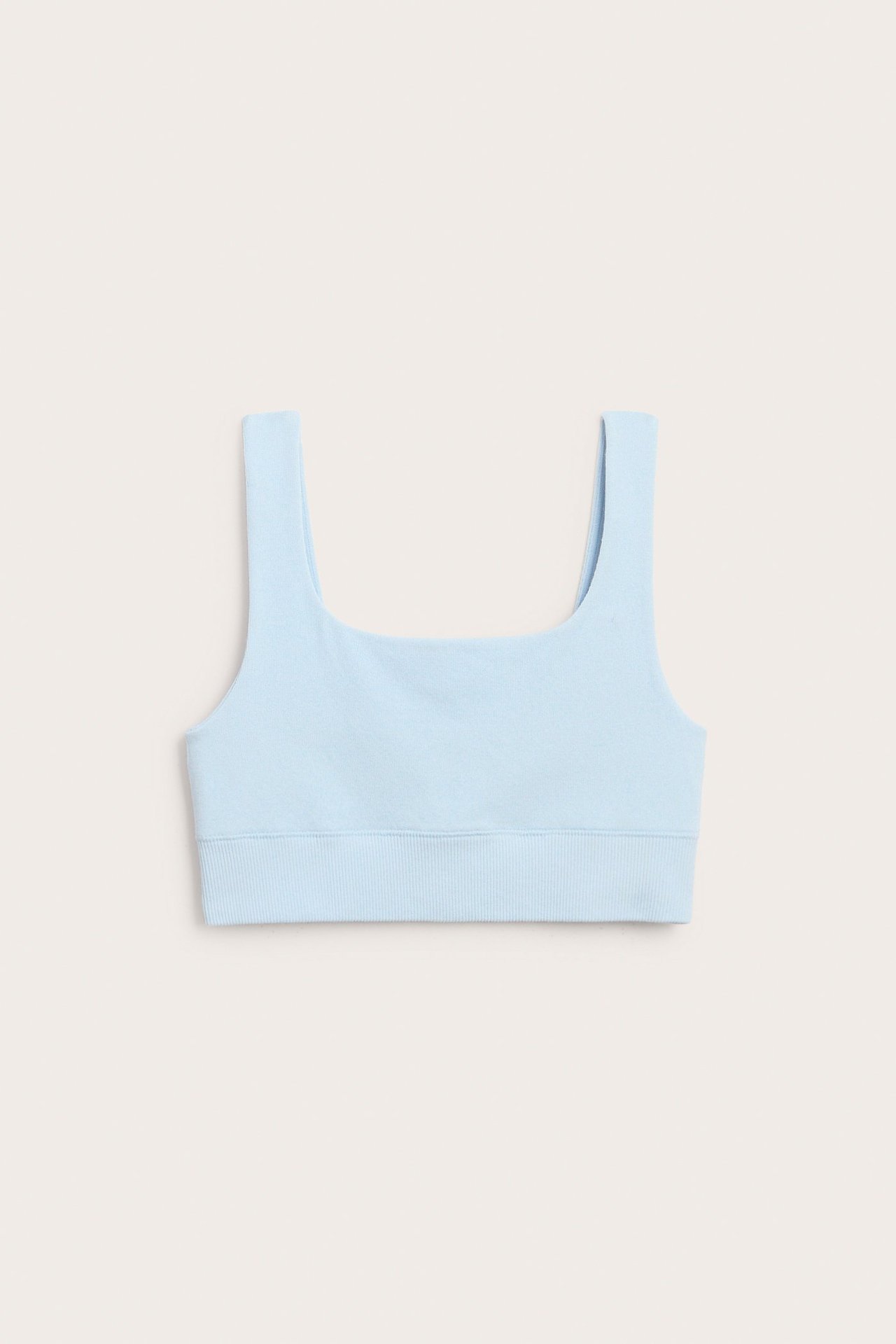 Frontvisning av en lyseblå BH-topp i bomullsblanding med firkantet halslinning og ribbet kant.