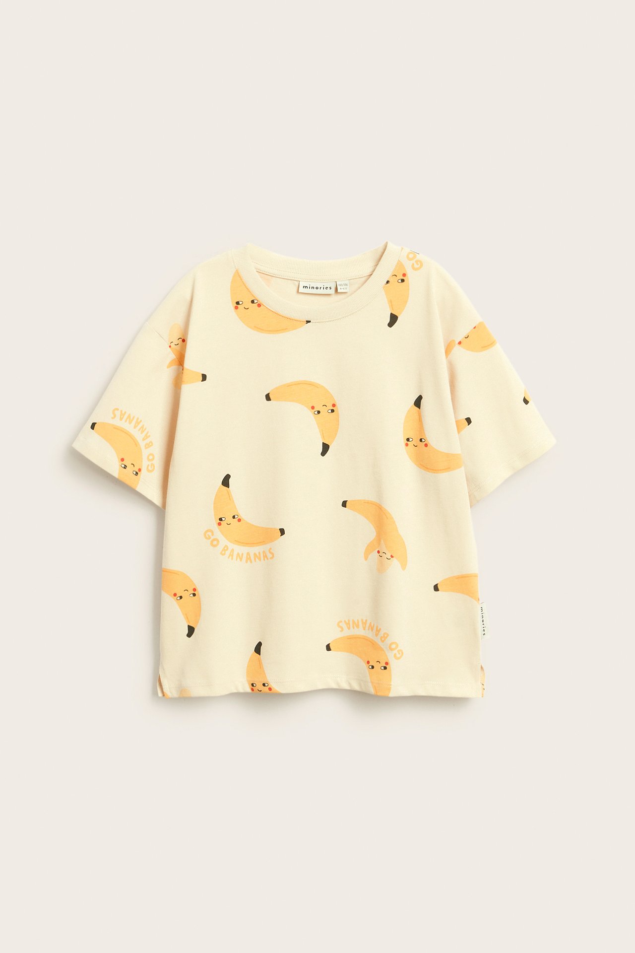 Framsida av en beige kortärmad T-shirt i bomull för barn med glatt banan- och 'Go Bananas'-tryck.