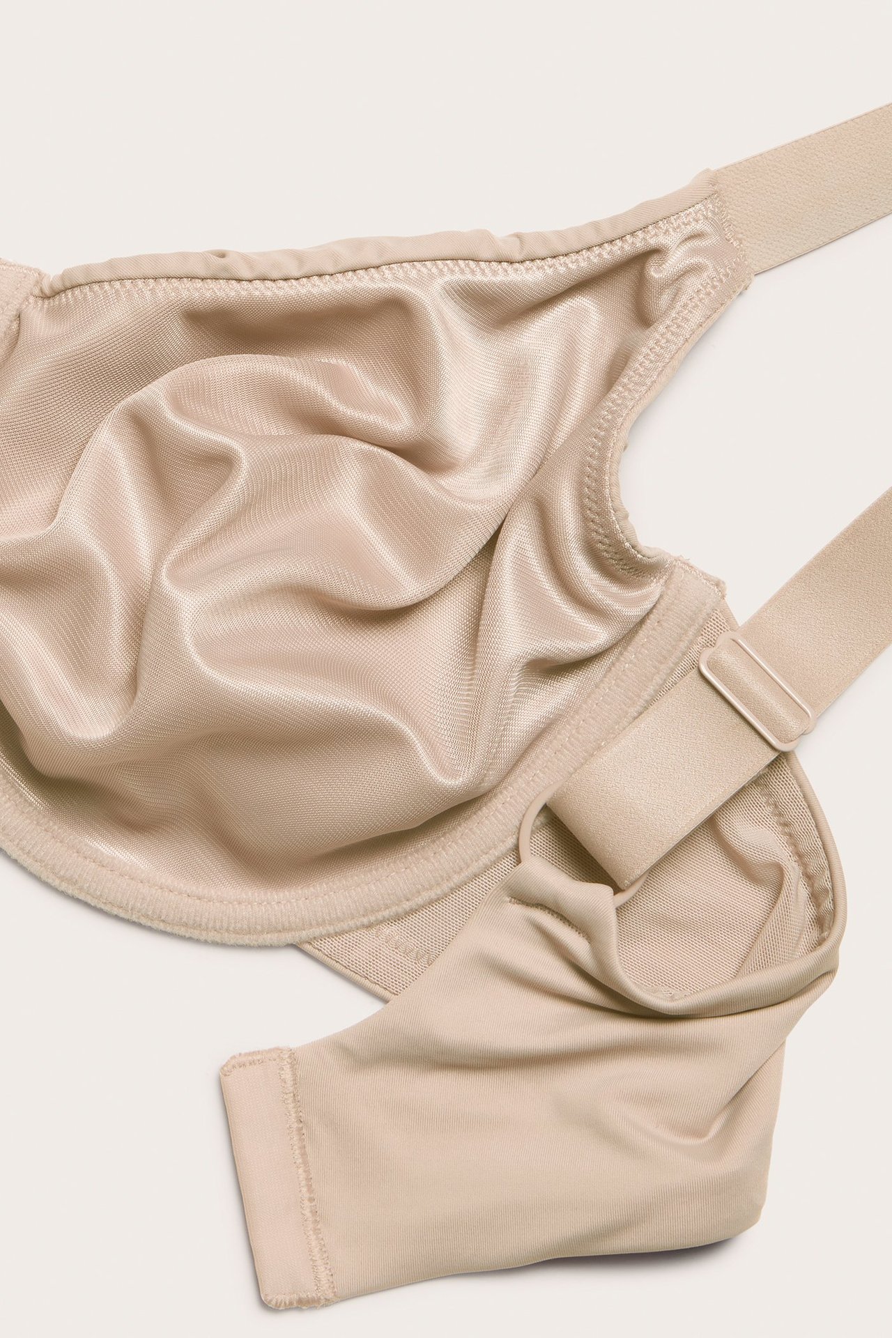 Nærbilde av en lys rosa ufôret minimizer-BH med spiler og justerbar stropp.