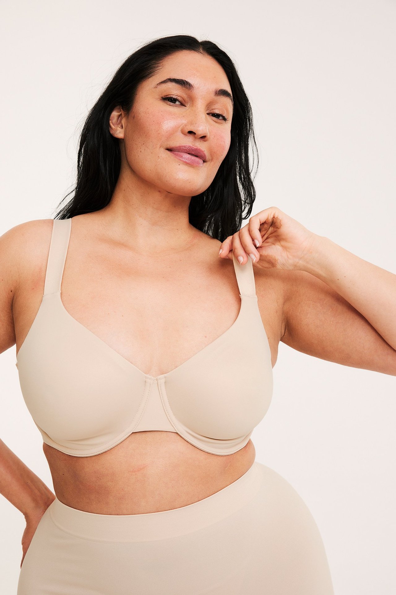 Edestäpäin: nainen vaaleanpunaisissa minimizer-kaarialiiveissä ja yhteensopivissa alushousuissa, säätää olkainta.