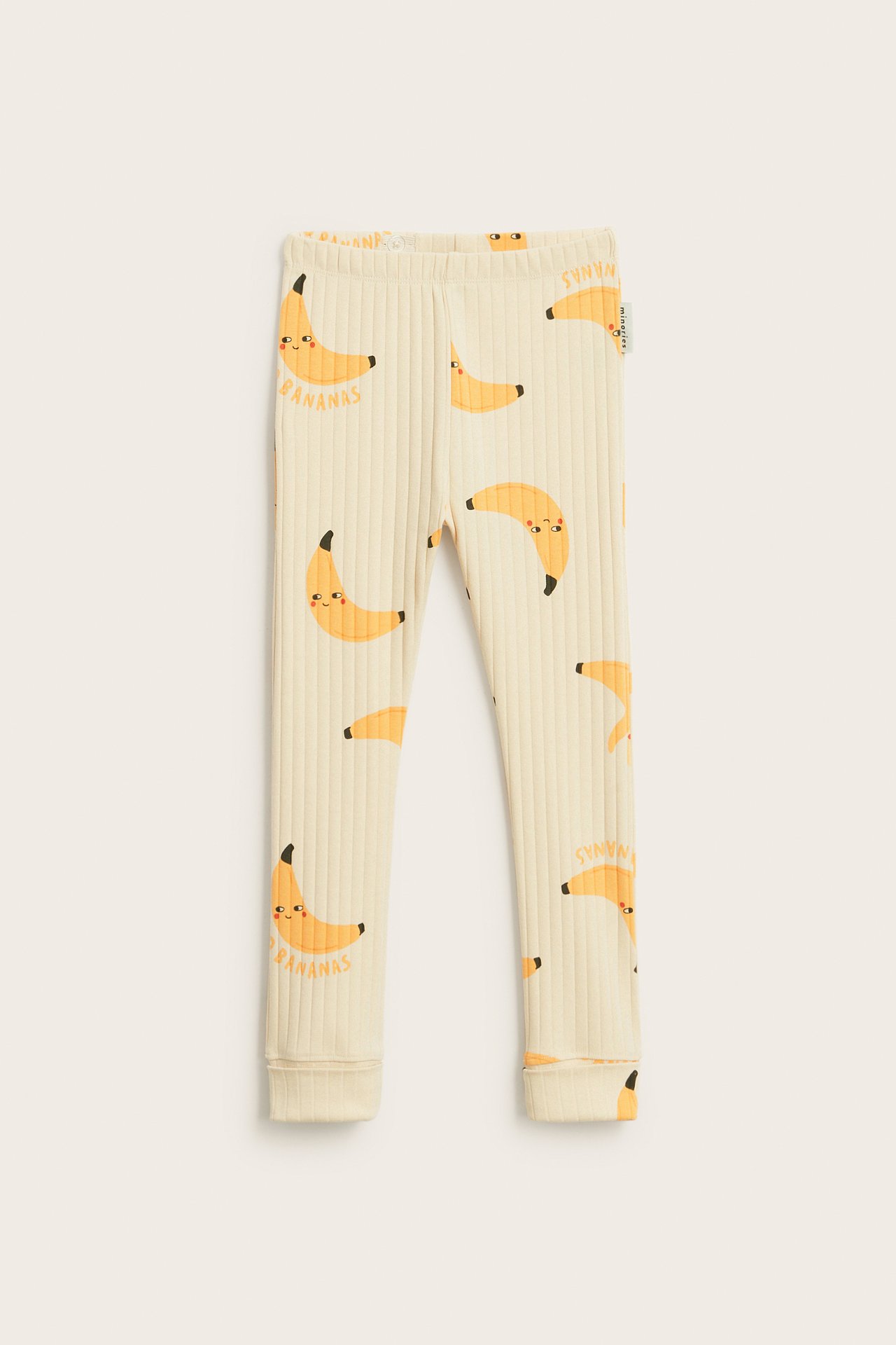 Framifrån: Beige ribbade leggings med bananmönster, reglerbar midja och nedvikbara muddar.