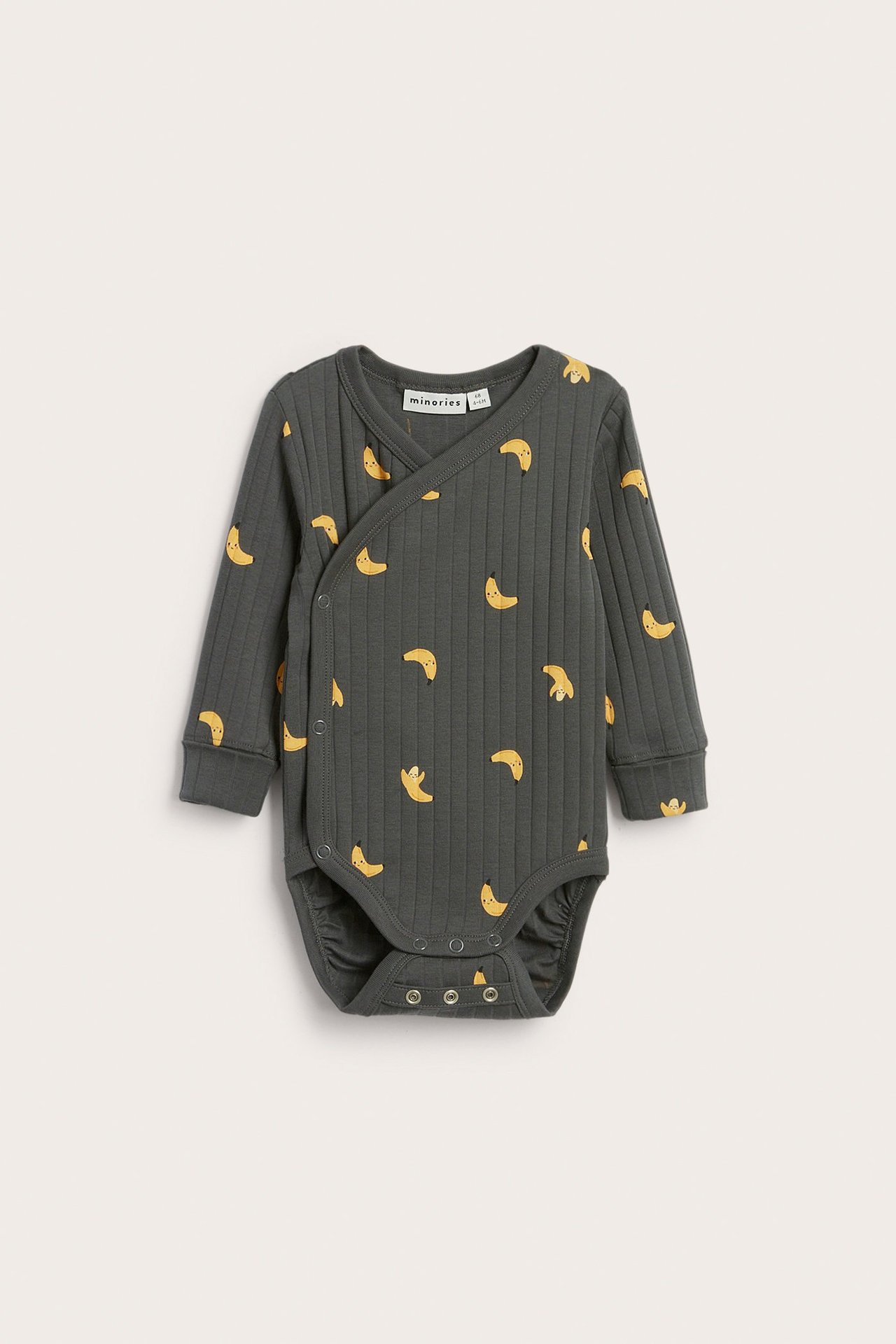 Etunäkymä: vauvan tummanharmaa ribbipitkähihainen kietaisubody keltaisella banaanikuviolla.