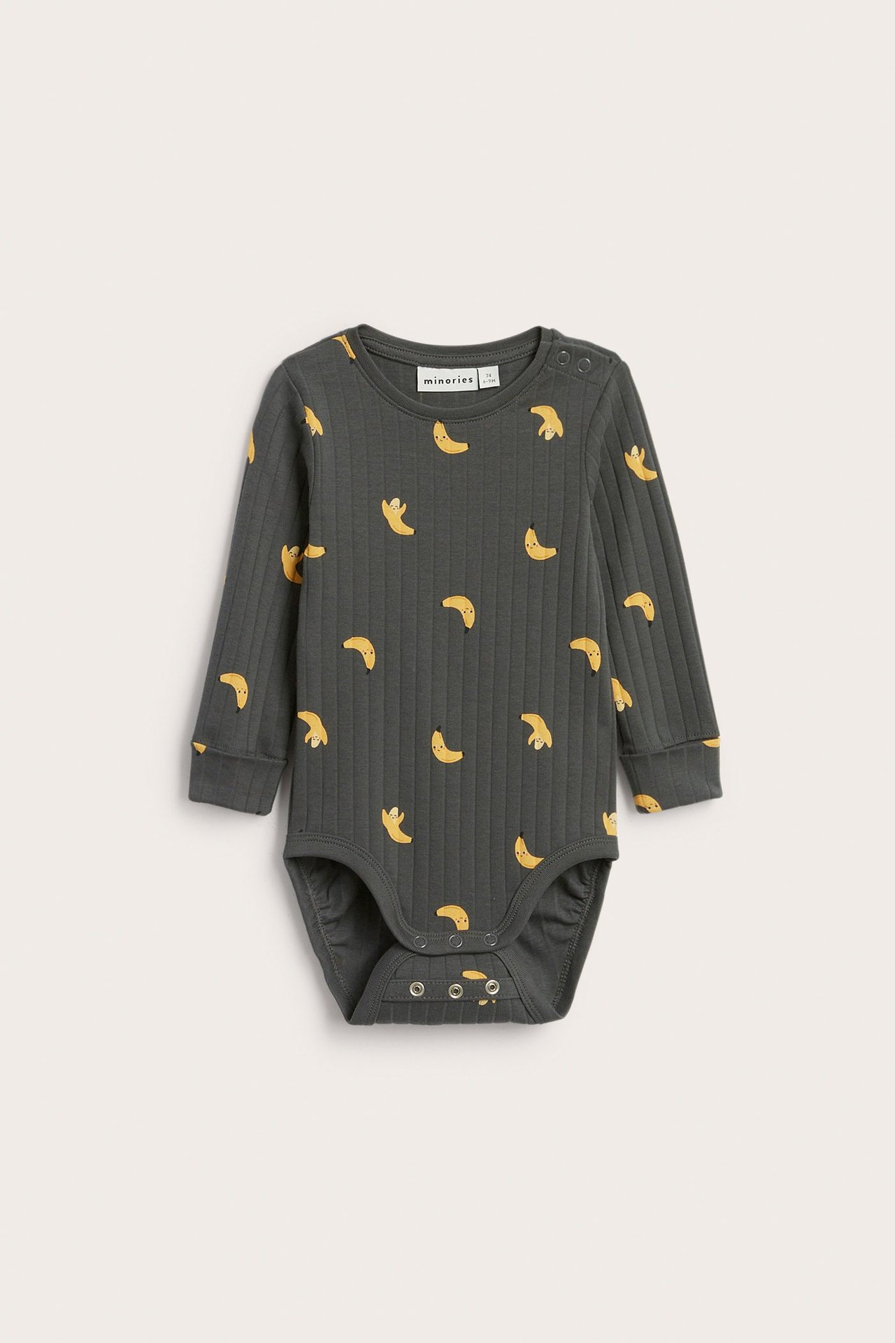 Edestä: vauvan tummanharmaa ribattu pitkähihainen body keltainen banaanikuvio ja nepparit.