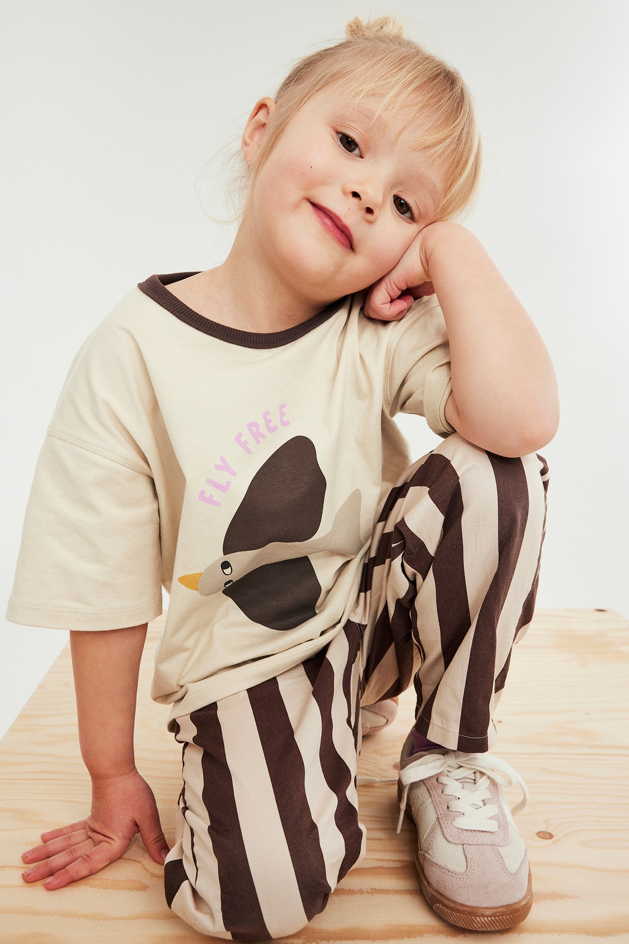Kortärmad t-shirt med fågelmönster i beige färg, barnmodell, framifrån, bomull.
