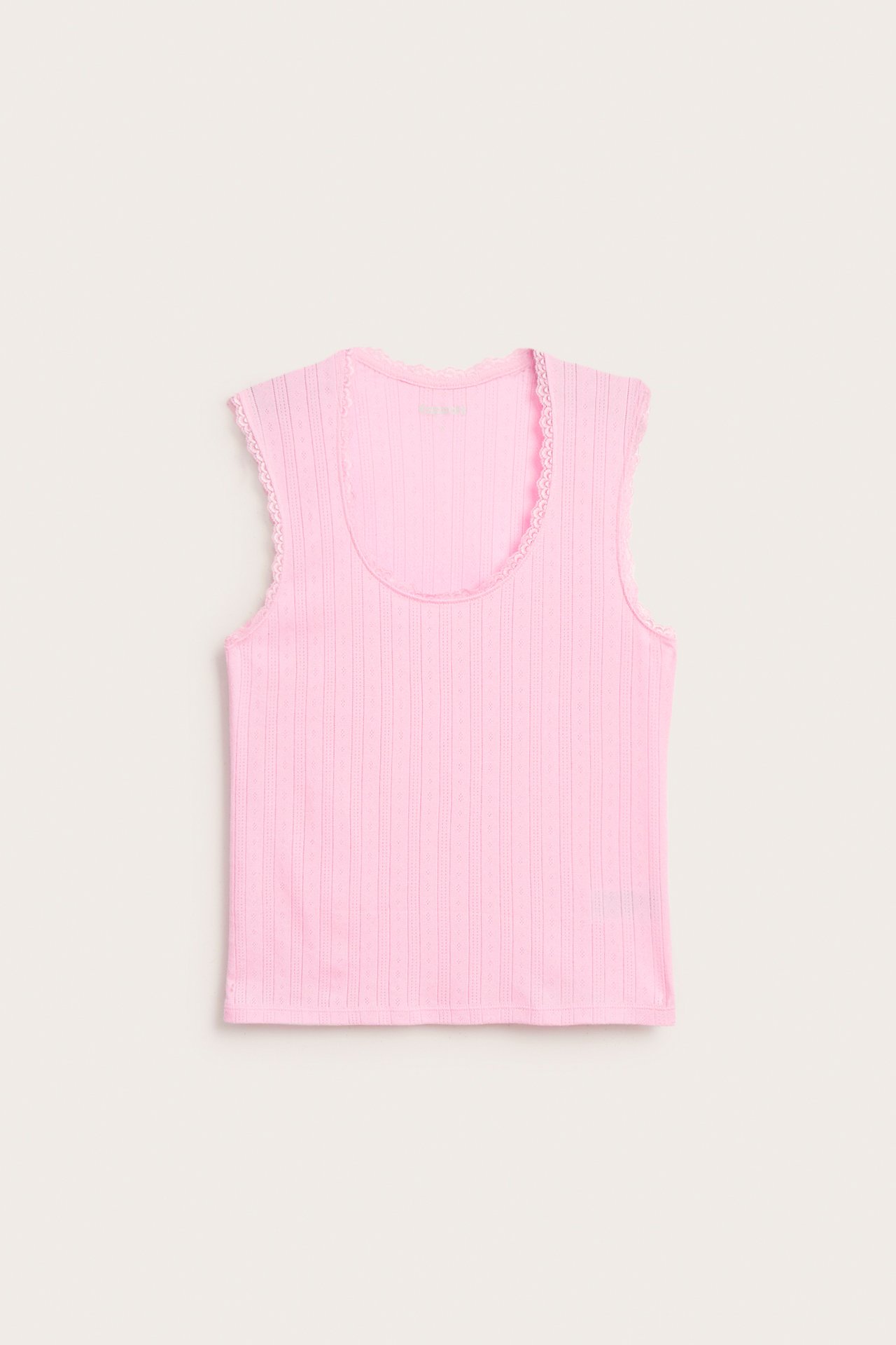 Framifrån, ett rosa pyjamaslinne i pointelle-trikå med ribbad struktur och fin spetskant.