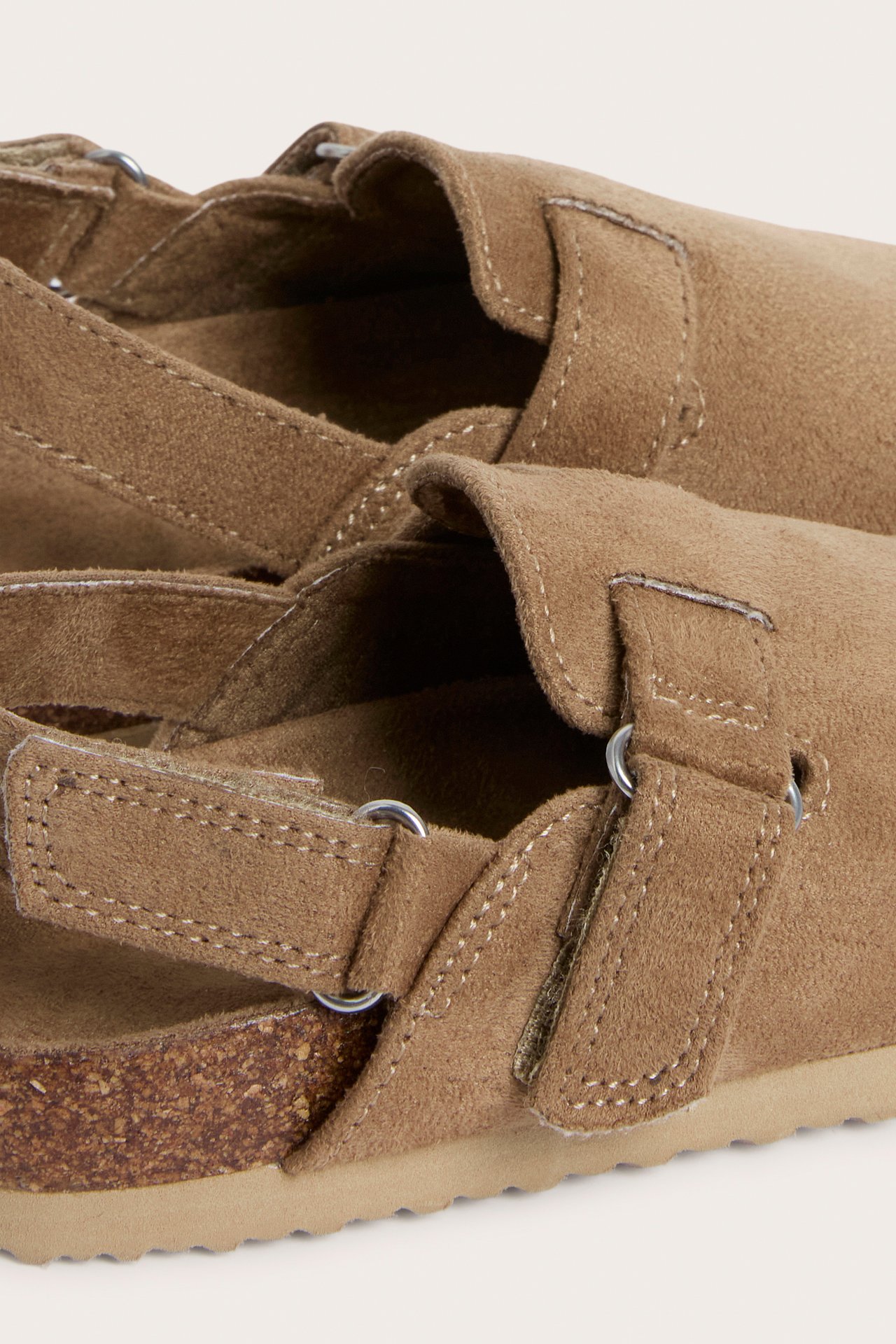 Lähikuva, sivukuva beigestä mokkajäljitelmä-lastentossusta, jossa korkkipohja ja tarranauhat.