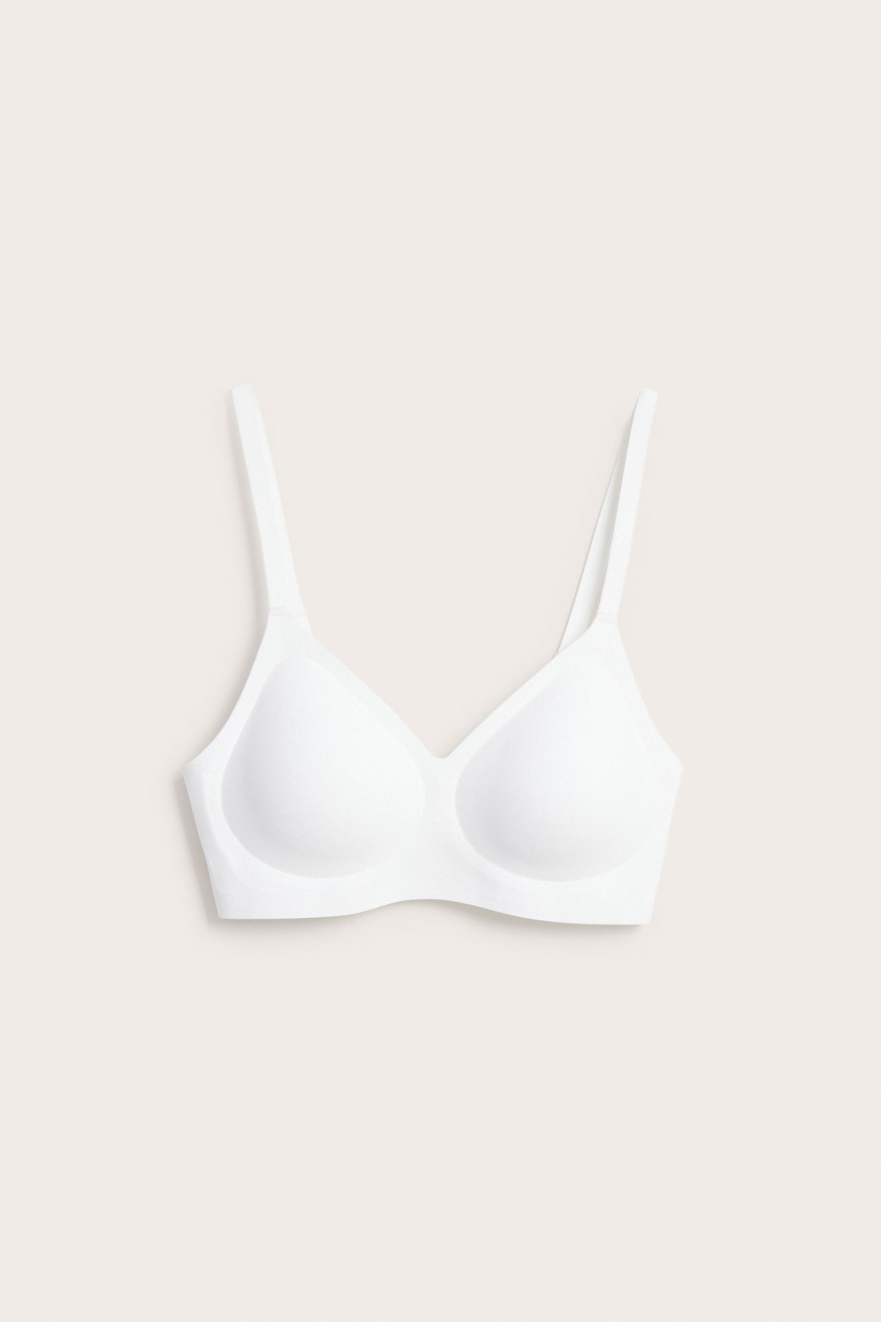 Valkoinen, kaaritueton rintaliivi edestä, valmistettu superpehmeästä, joustavasta mikrokankaasta V-pääntie.