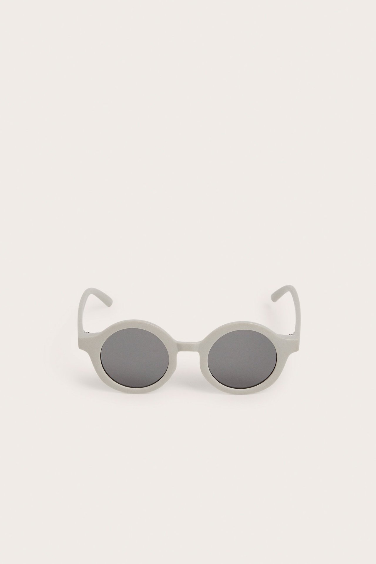 Widok z przodu jasnobeżowych okrągłych okularów przeciwsłonecznych z recyklingu plastiku.