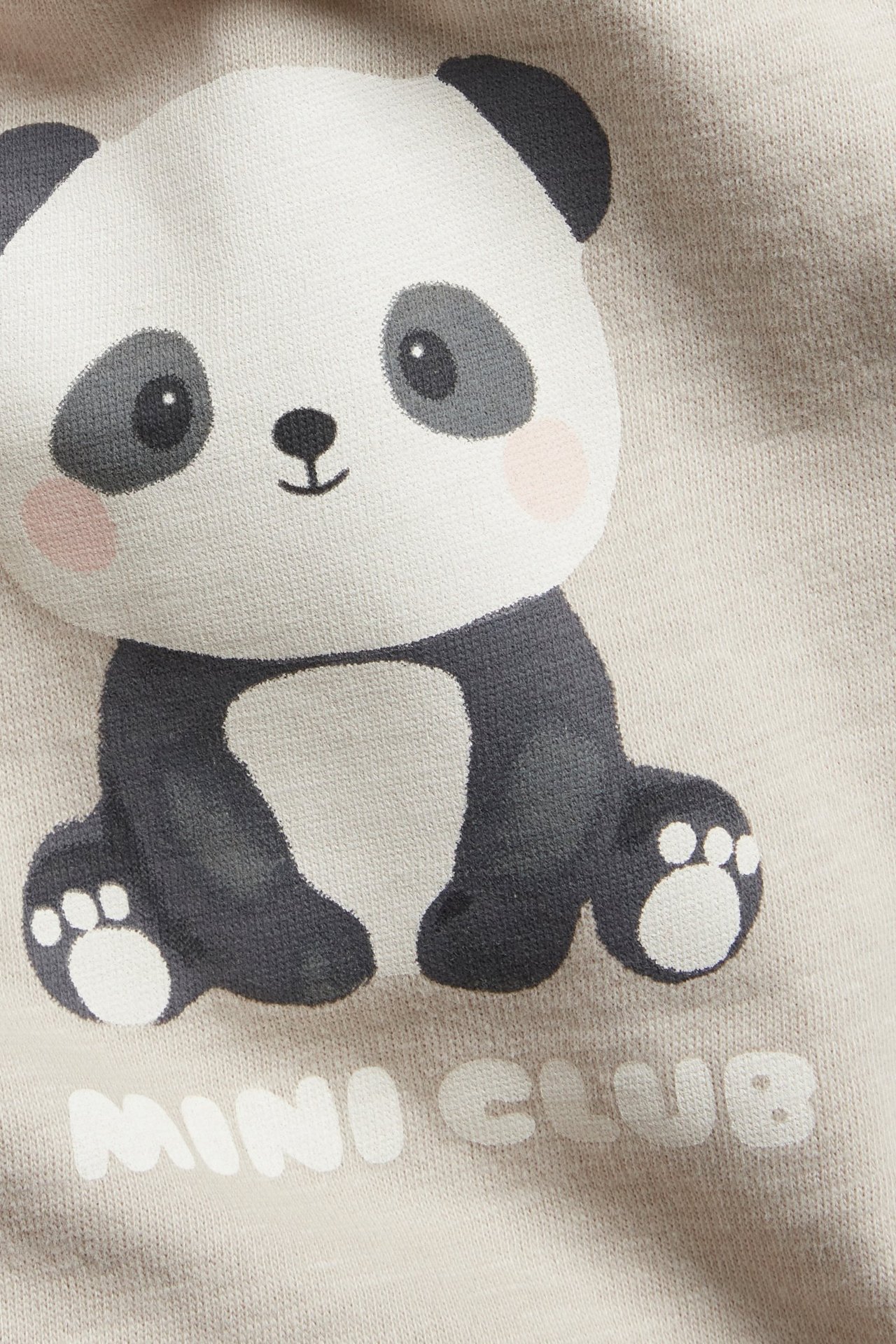 Nærbilde av en beige bomullslub langermet t-skjorte for baby med pandatrykk og 'MINI CLUB'-tekst.