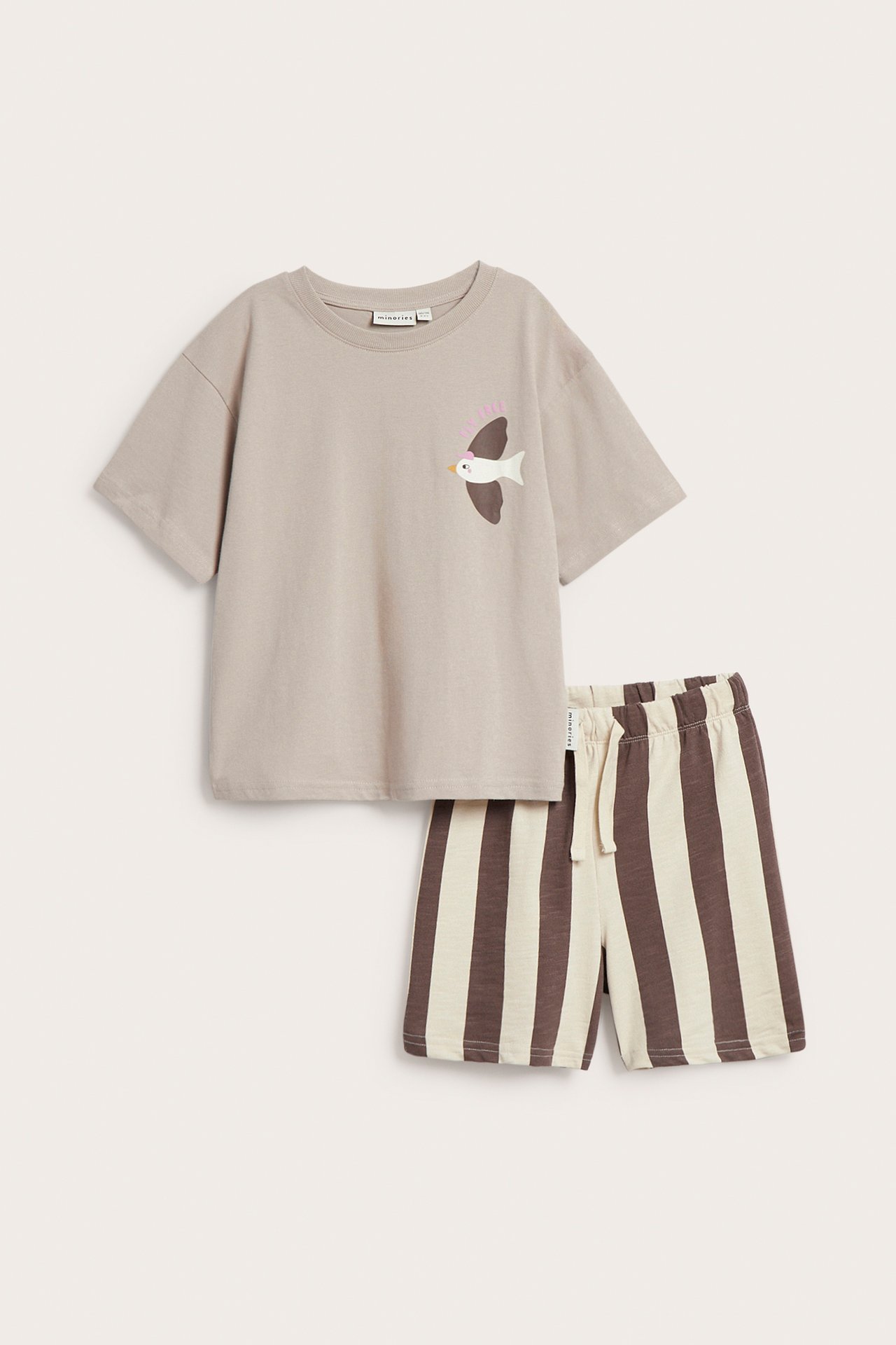 Edestä: Lasten beige puuvillapaita lintupainatuksella ja ruskea-valkoraidalliset shortsit joustovyötäröllä.