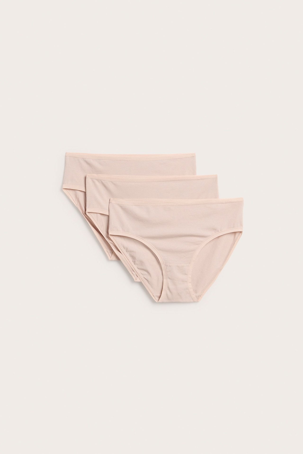 Sett forfra, en 3-pakning ensfargede lys rosa bomullstruser i brief-modell, lagt på lys bakgrunn.