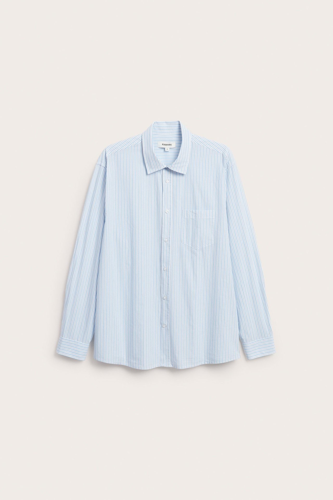 Widok z przodu jasnoniebieskiej bawełnianej koszuli w paski z klasycznym kołnierzykiem i kieszenią na piersi.