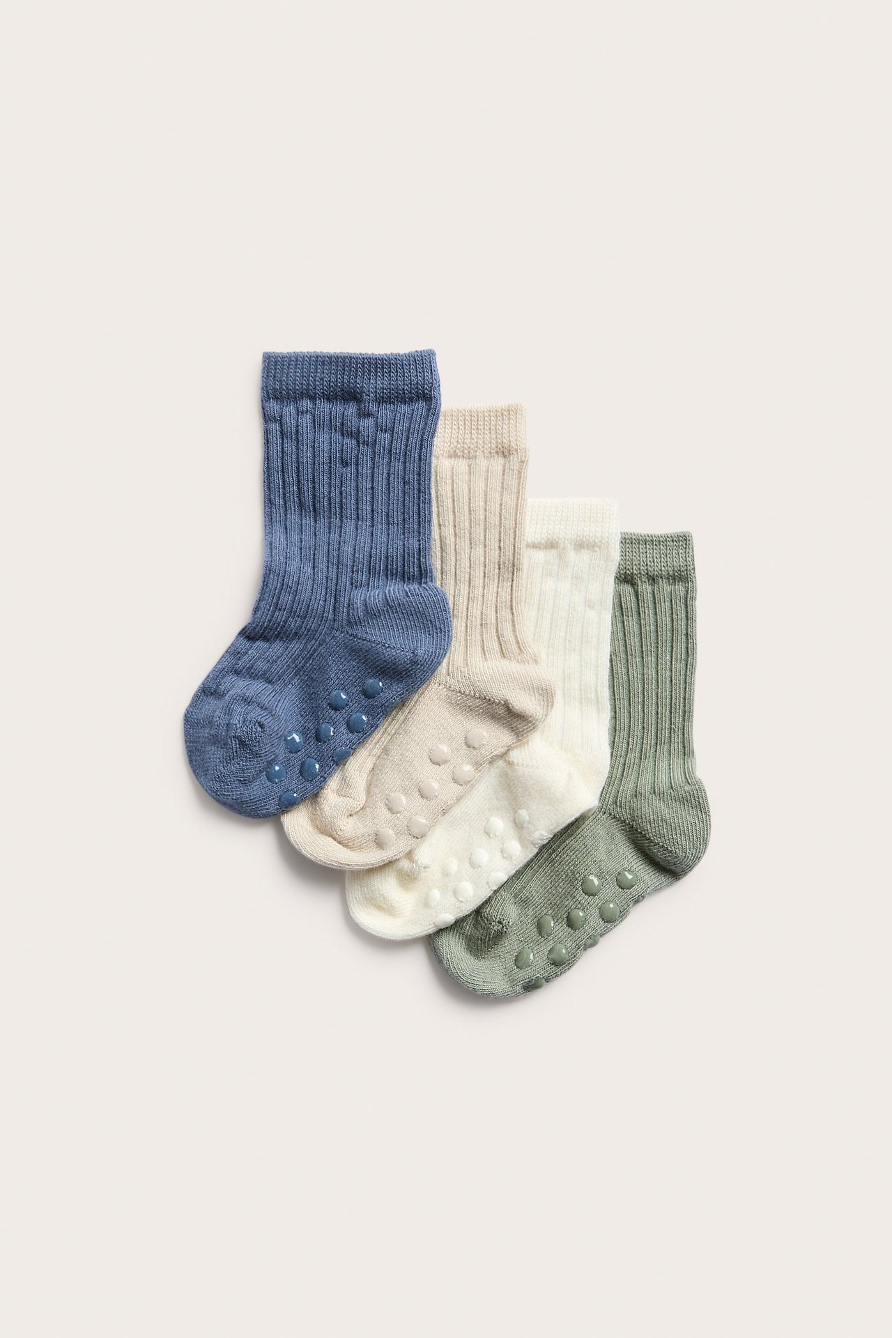 Cztery pary prążkowanych skarpetek niemowlęcych: niebieskie, beżowe, białe i zielone, z antypoślizgiem.