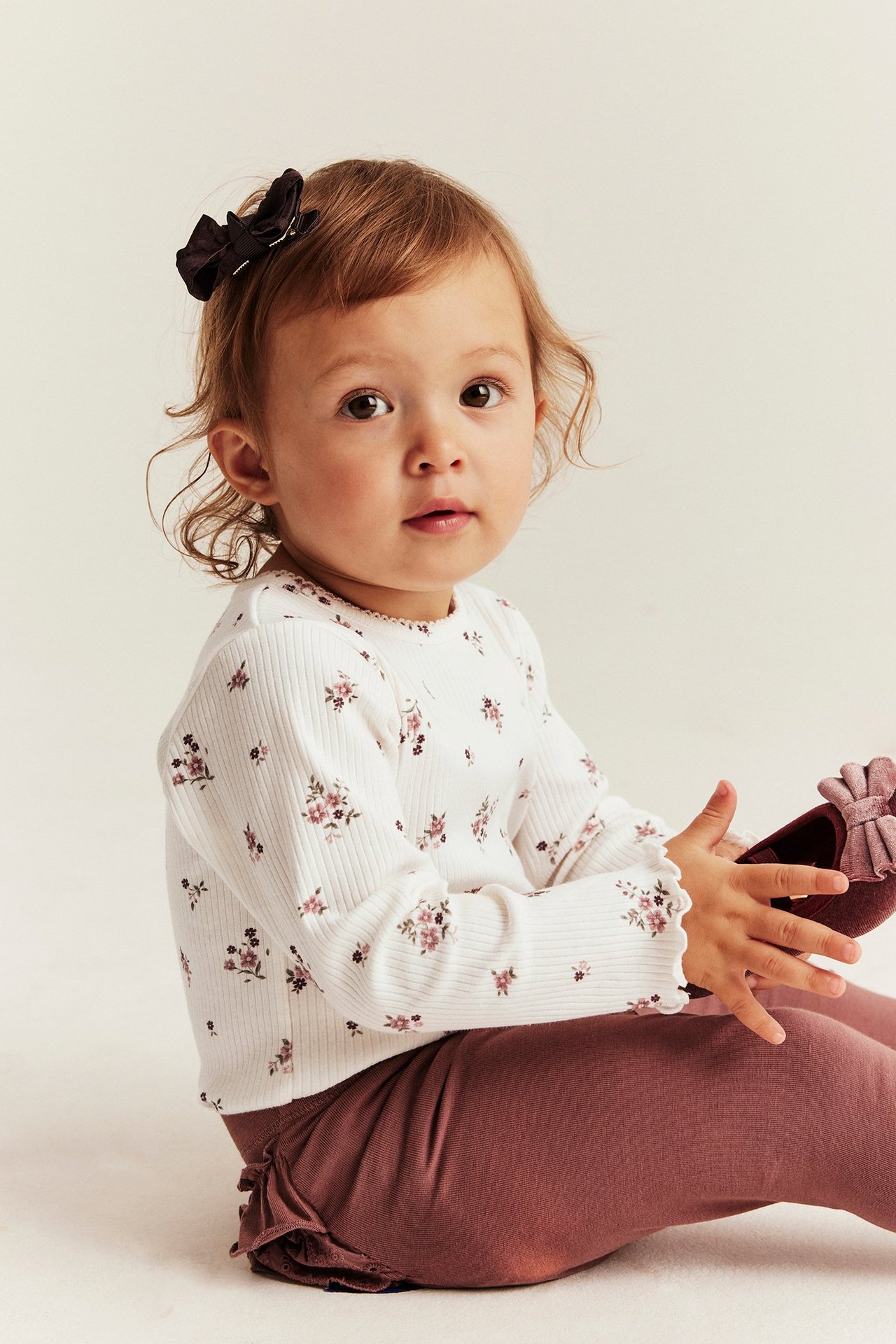 Pitkähiha, kukkainen, ribbava body offwhite-värissä, vågig hihansuissa ja niiteissä.