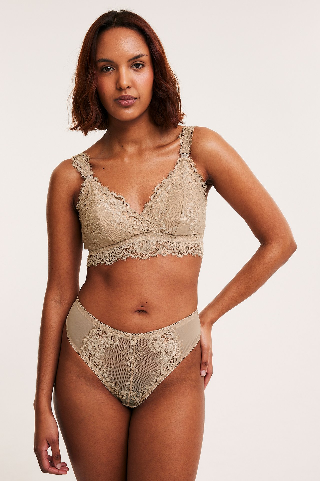 Framifrån: kvinna i brun amnings-bh i spets med clips och matchande högt skurna spetsunderbyxor.