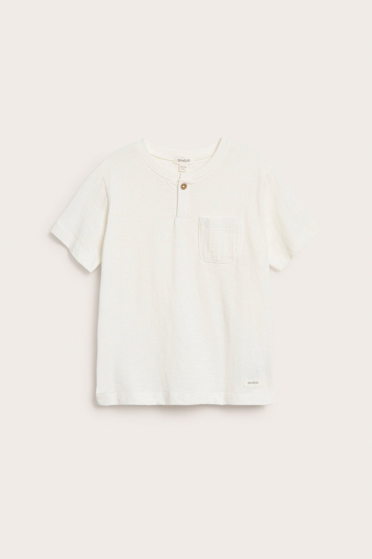 Edestäpäin, luonnonvalkoinen lasten slub-neule T-paita napillisella halkiolla ja rintataskulla.