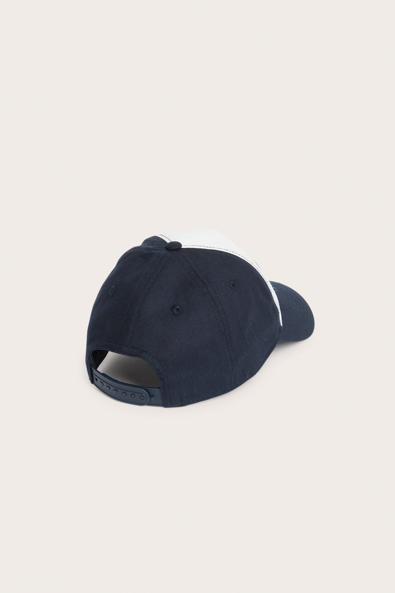 Widok z tyłu: dwukolorowa granatowo-biała czapka z daszkiem z zapięciem typu snapback.