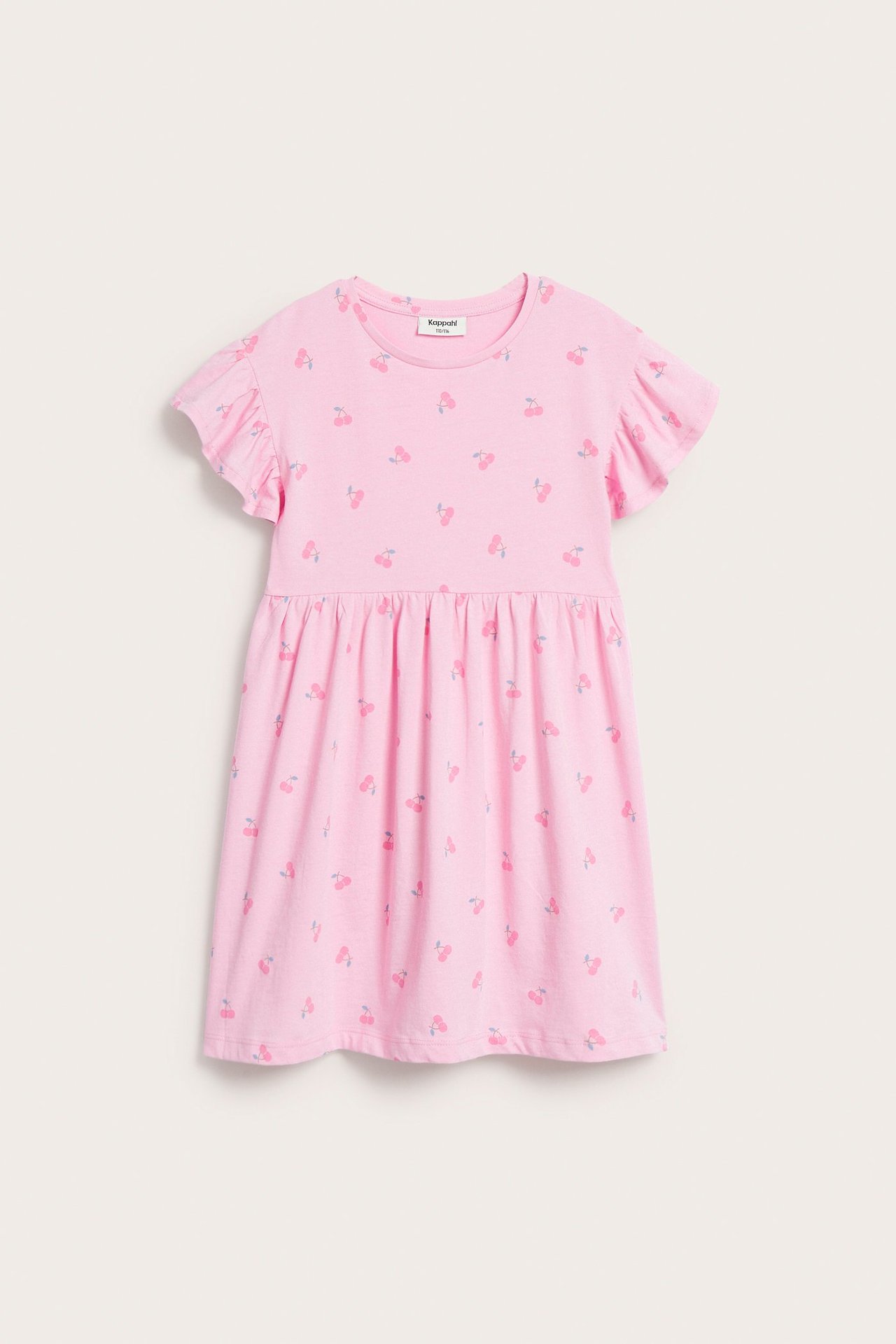 Frontbilde av en lys rosa bomullskjole for barn med kirsebærmønster og korte volangermer.