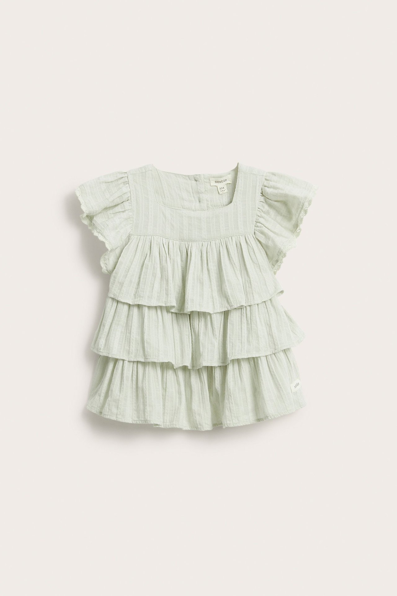 Widok z przodu: Jasnozielona bluzka niemowlęca z falbanami, kwadratowym dekoltem i koronkowymi rękawami.