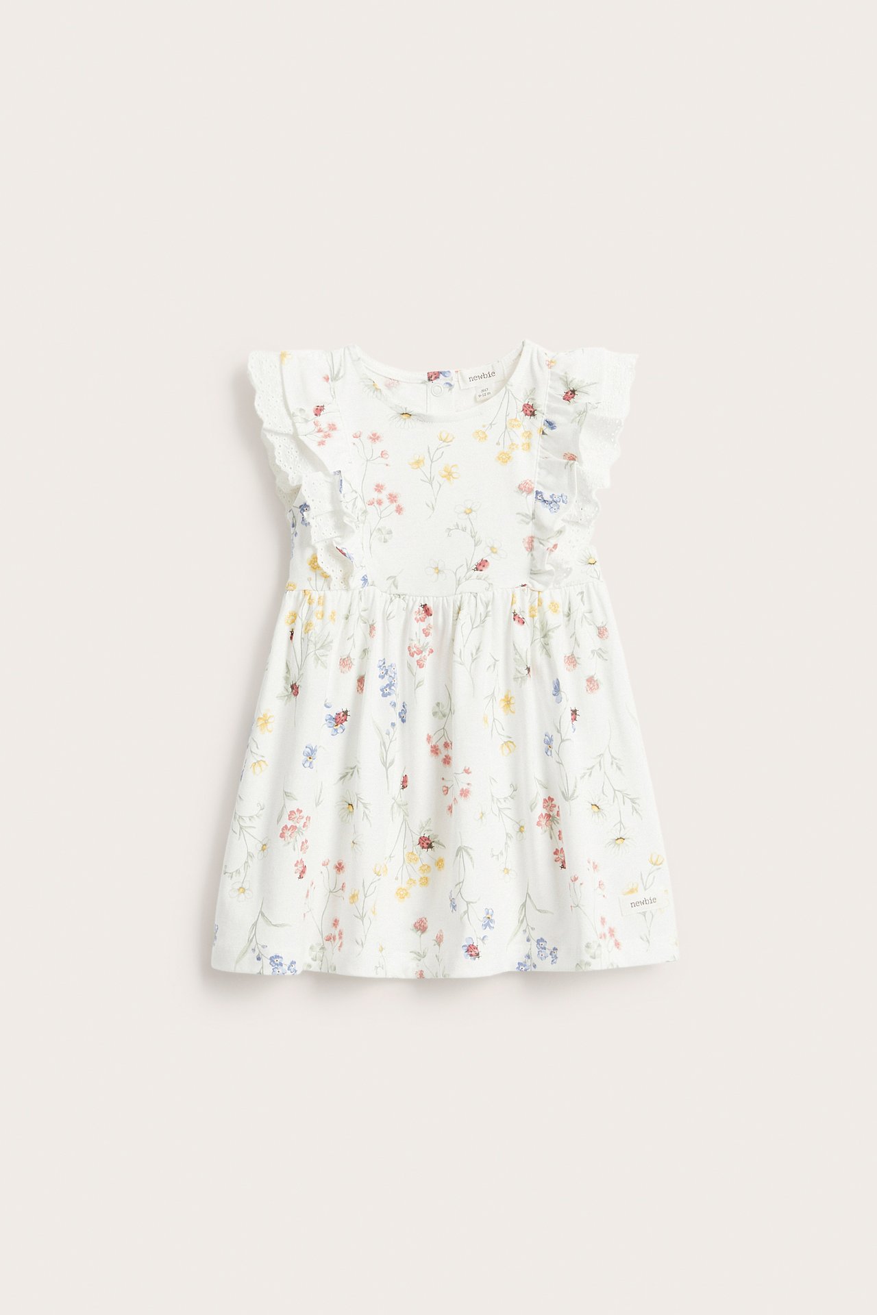 Frontvisning av en offwhite jerseykjole for barn med volangermer, blondedetaljer og fargerikt blomstermønster.