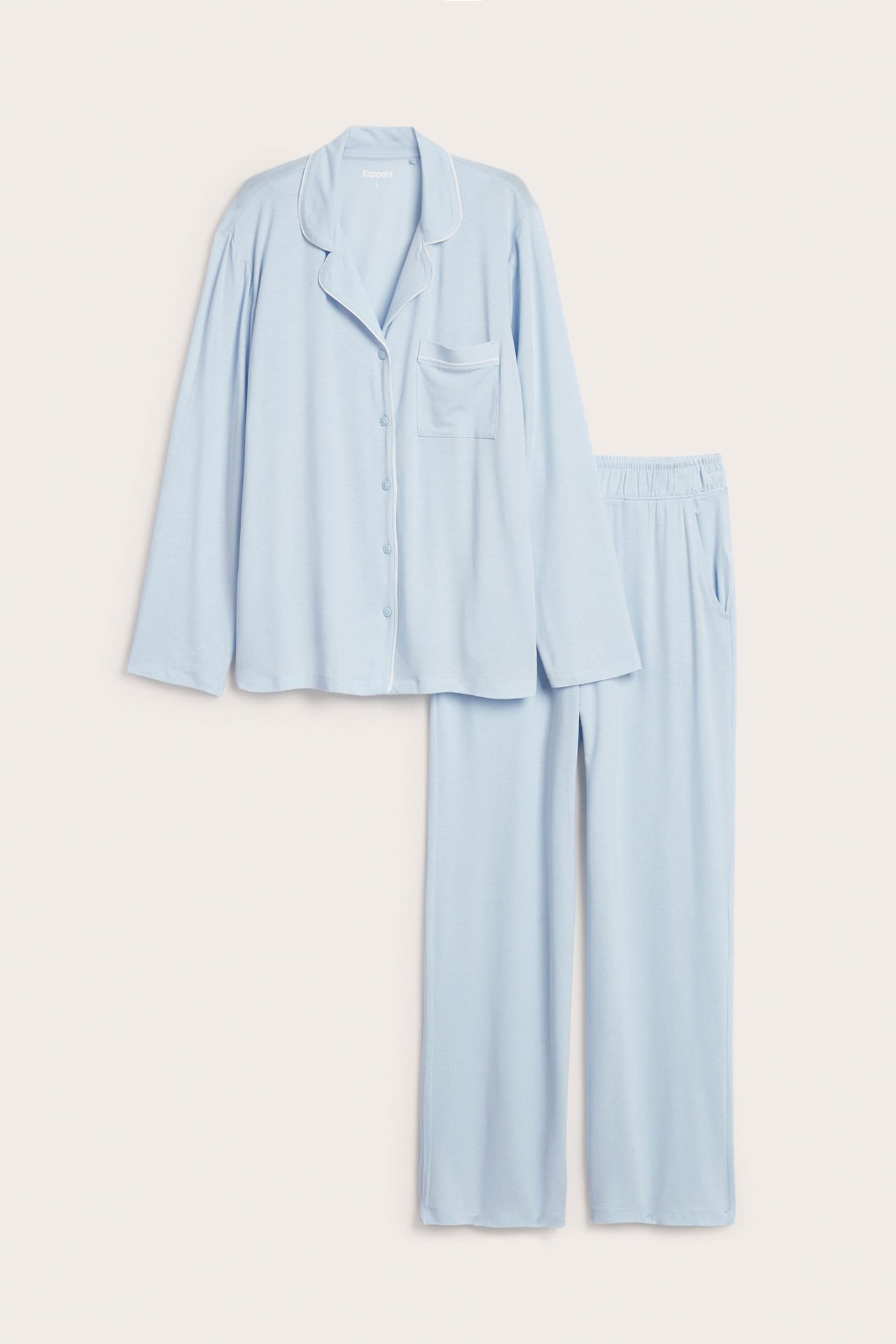 Edestä: vaaleansininen lyocell-pyjamassetti, kauluspaita, valkoiset tereet ja suorat housut.