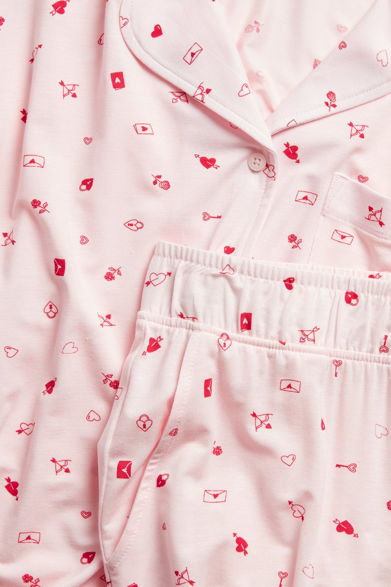 Zbliżenie na różową piżamę lyocell w deseń, koszula z kołnierzykiem, spodnie z elastycznym pasem.