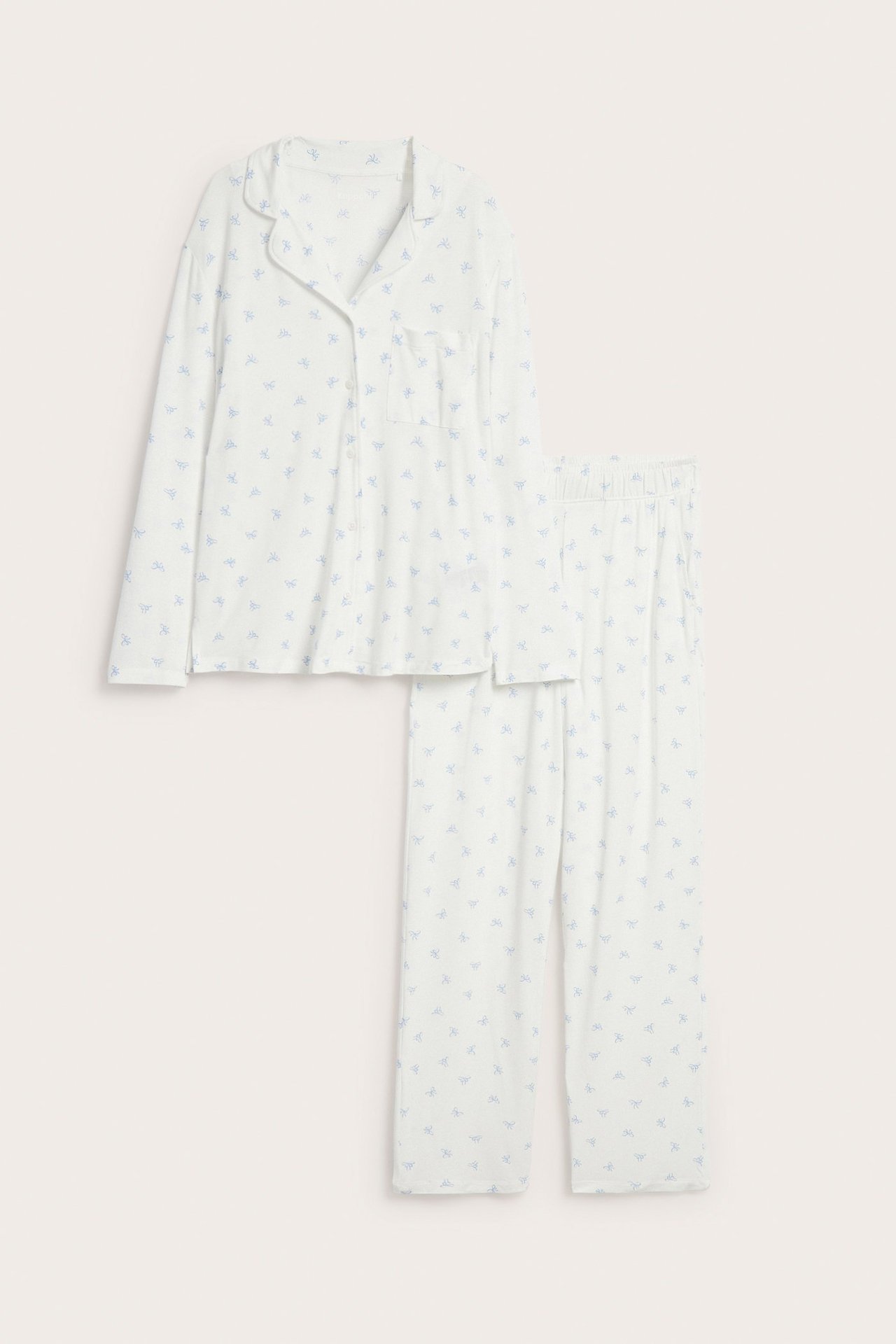 Forfra: Offwhite lyocell-pyjamas med blått sløyfemønster, knappeskjorte og rette bukser.