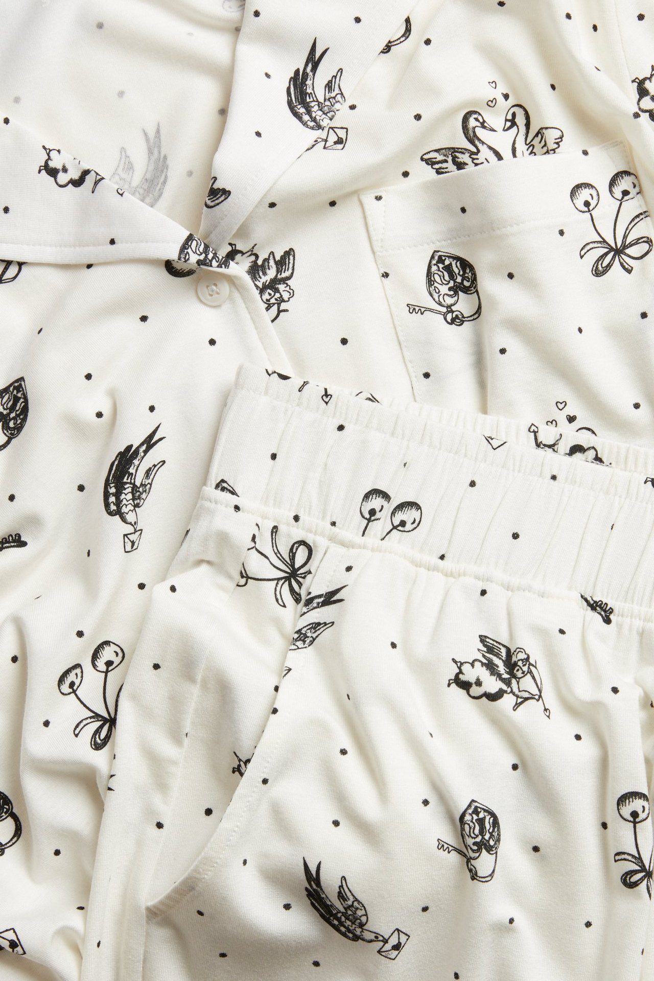 Zbliżenie kremowej, wzorzystej piżamy damskiej z lyocellu: koszula na guziki i spodnie z gumką.